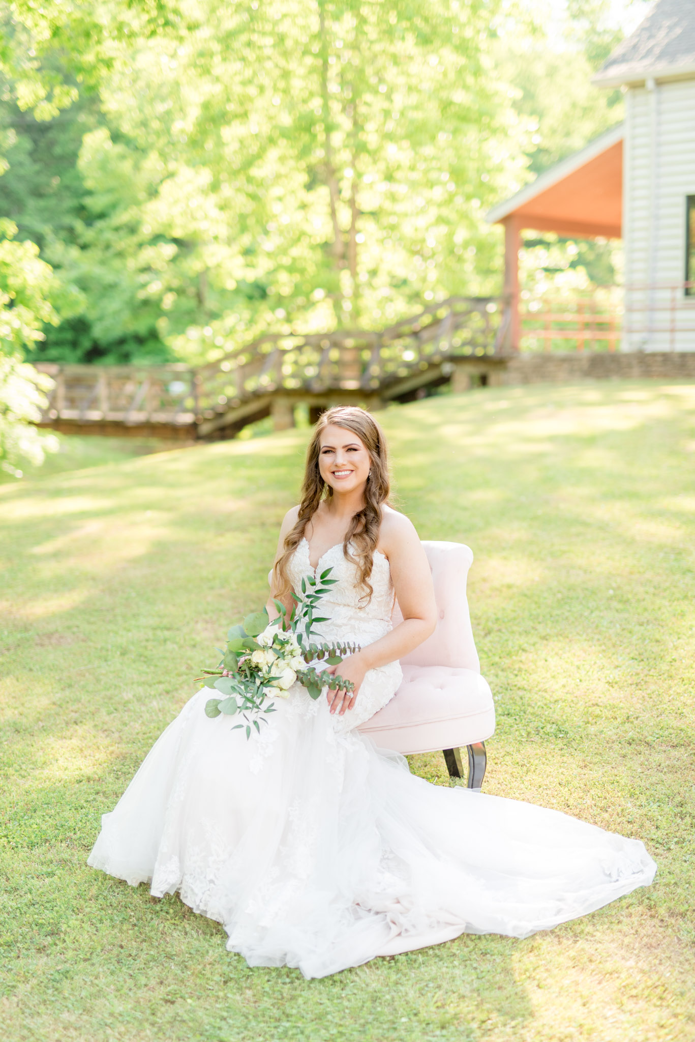 Bride sits on chair and smiles at camera.