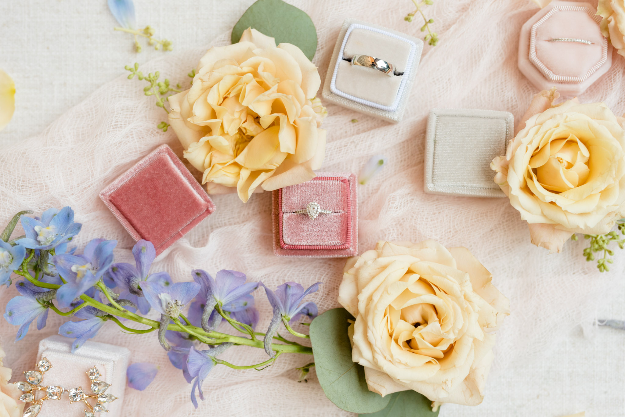 Bridal jewelry in boxes with flowers.