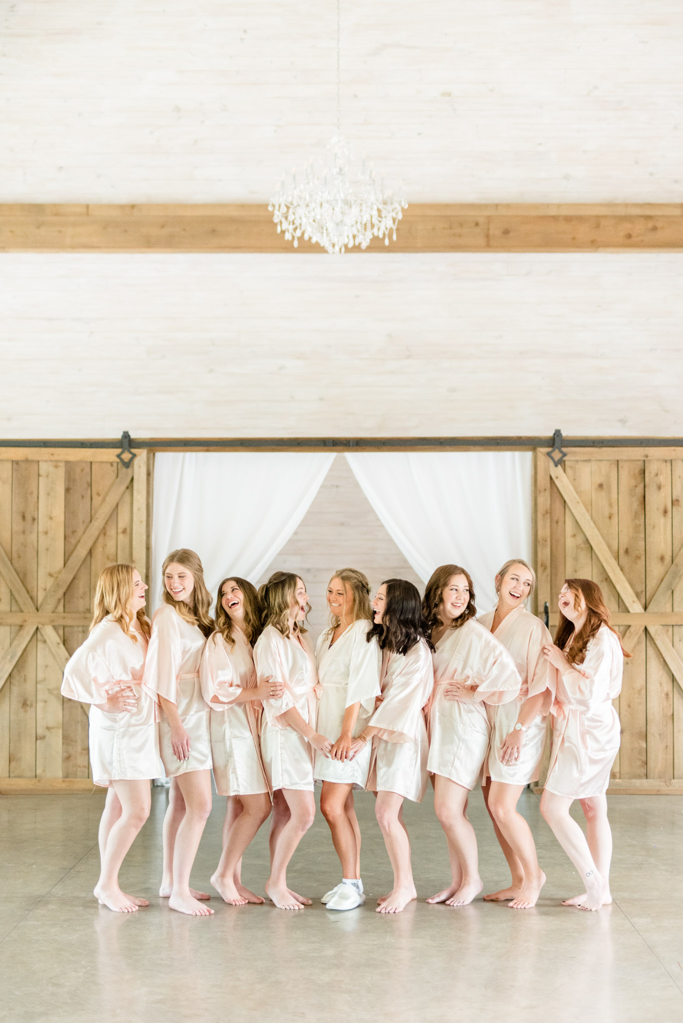 Bridal party laugh while getting ready.