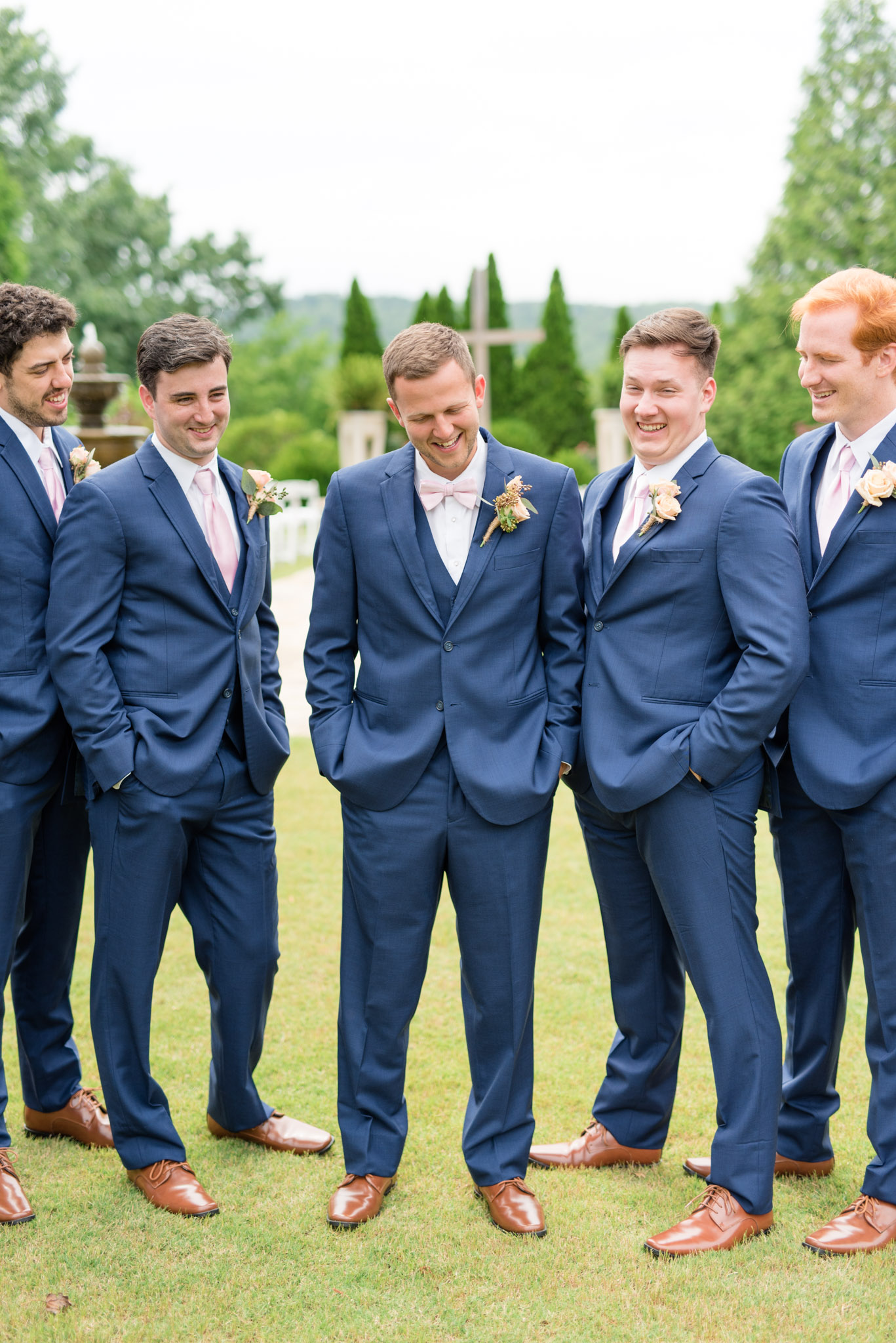 Groom and groomsmen laugh together.