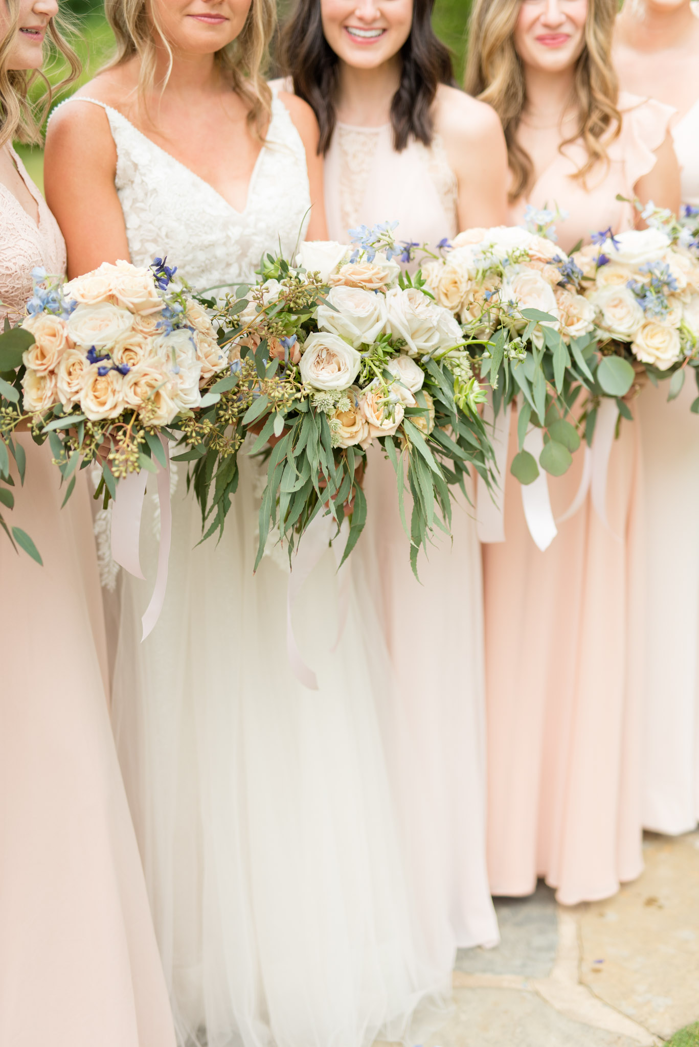 Bride and bridesmaids hold bouquets.