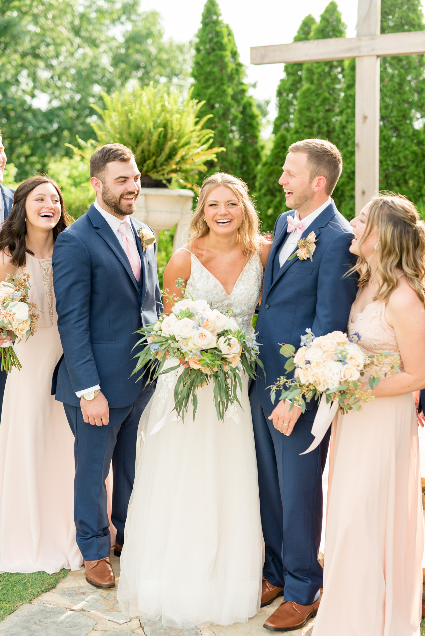 Bride laughs with wedding party.