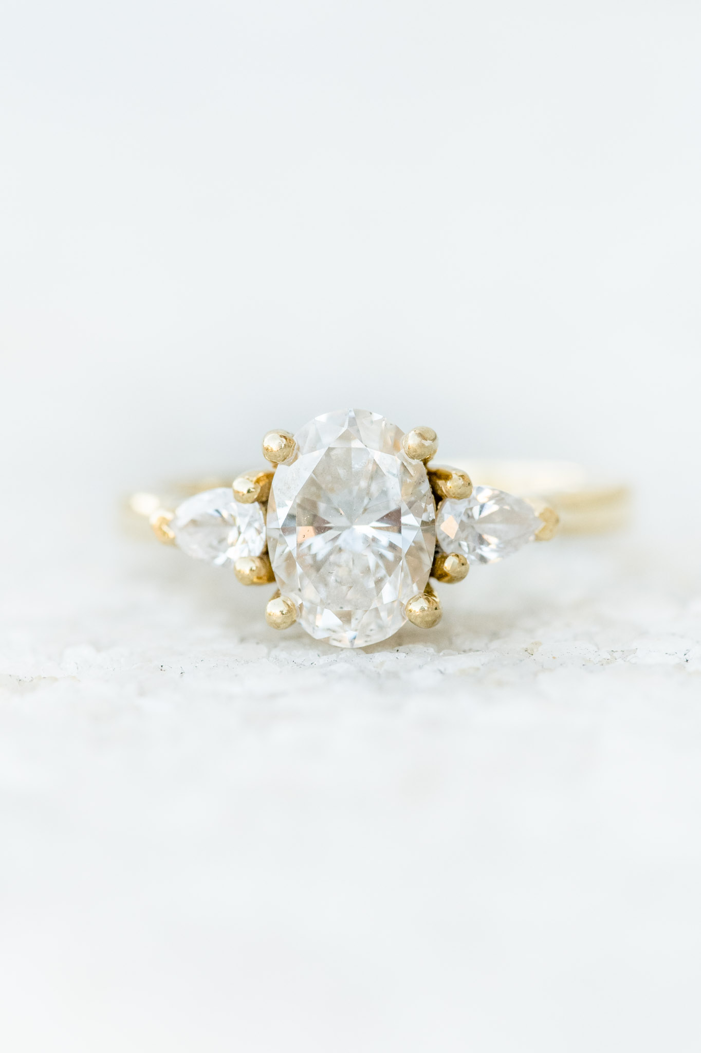 Oval engagement ring sits on stone.