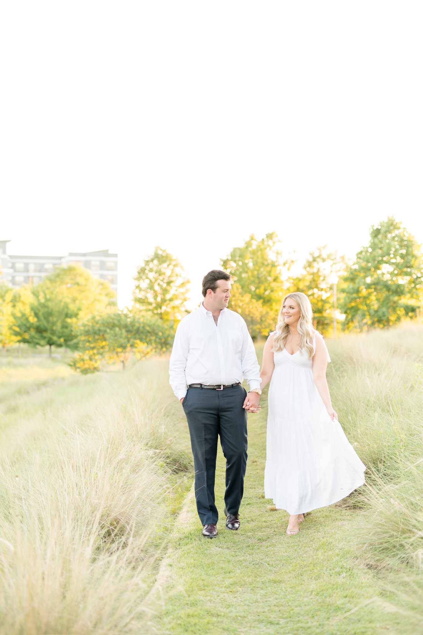 Couple walks through tall grass.