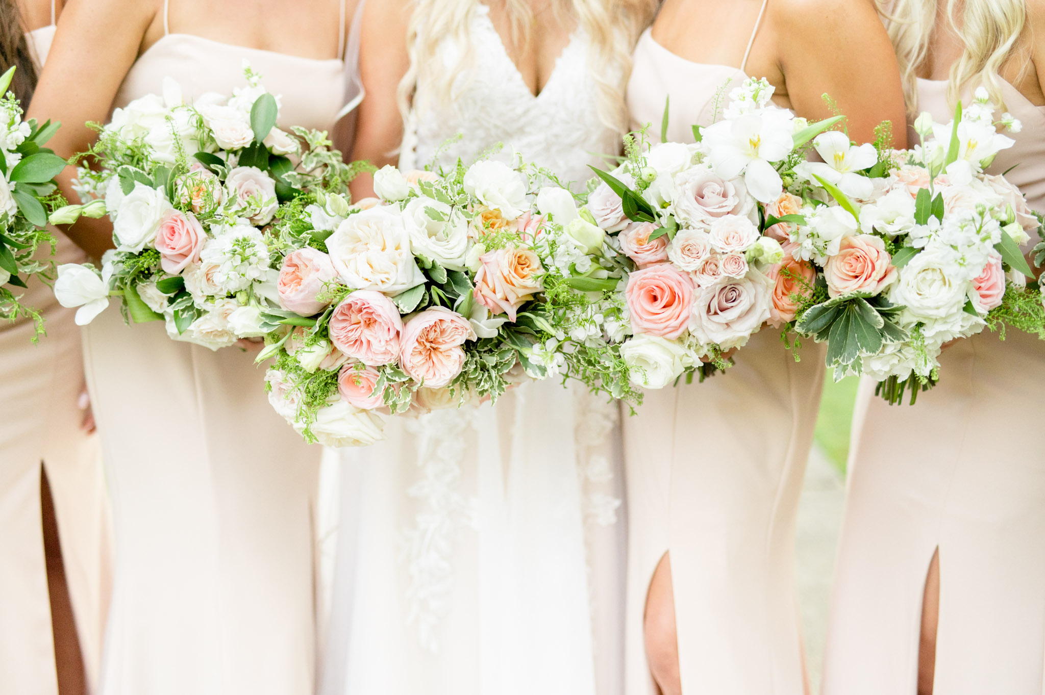 Pink and white flowers held by bridal party.