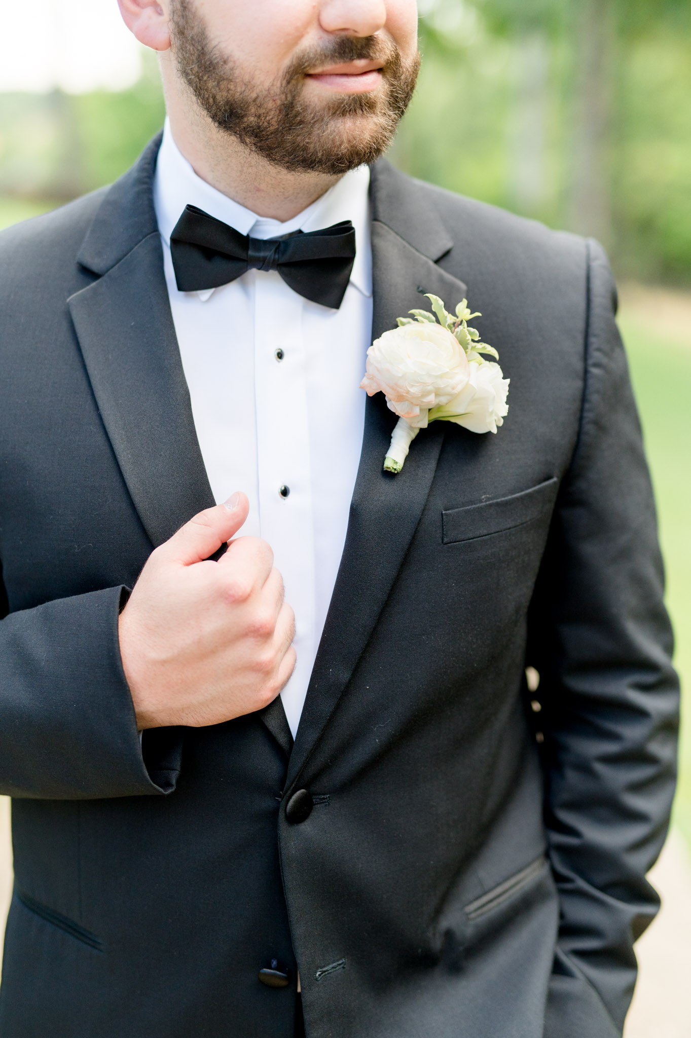 Closeup of groom's tux and boutonniere. 
