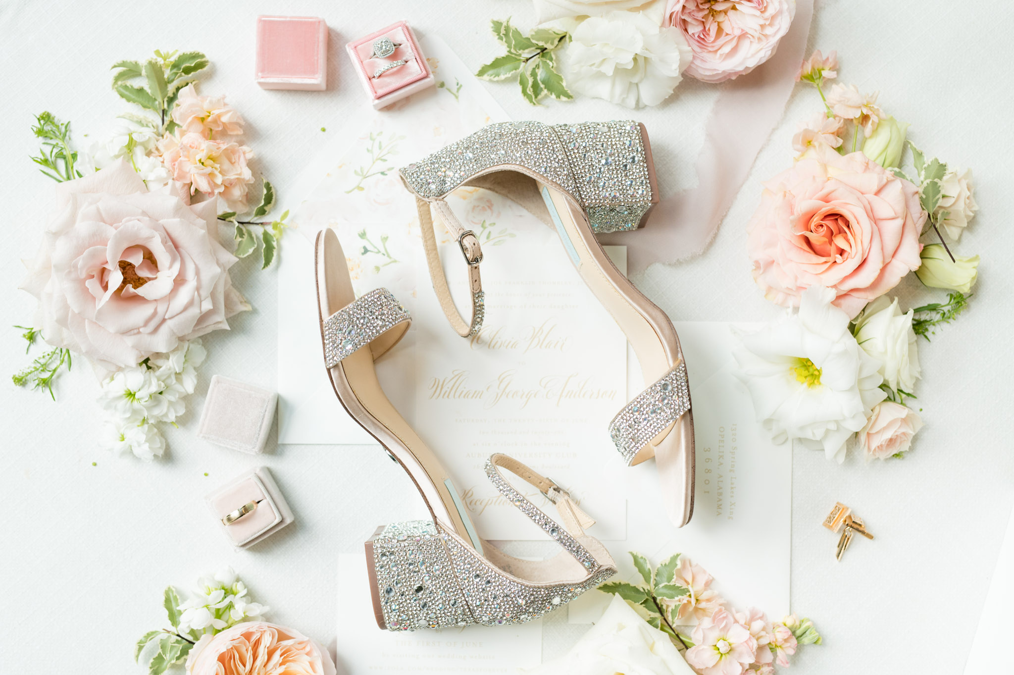 Bride's shoes sit with flowers and rings.