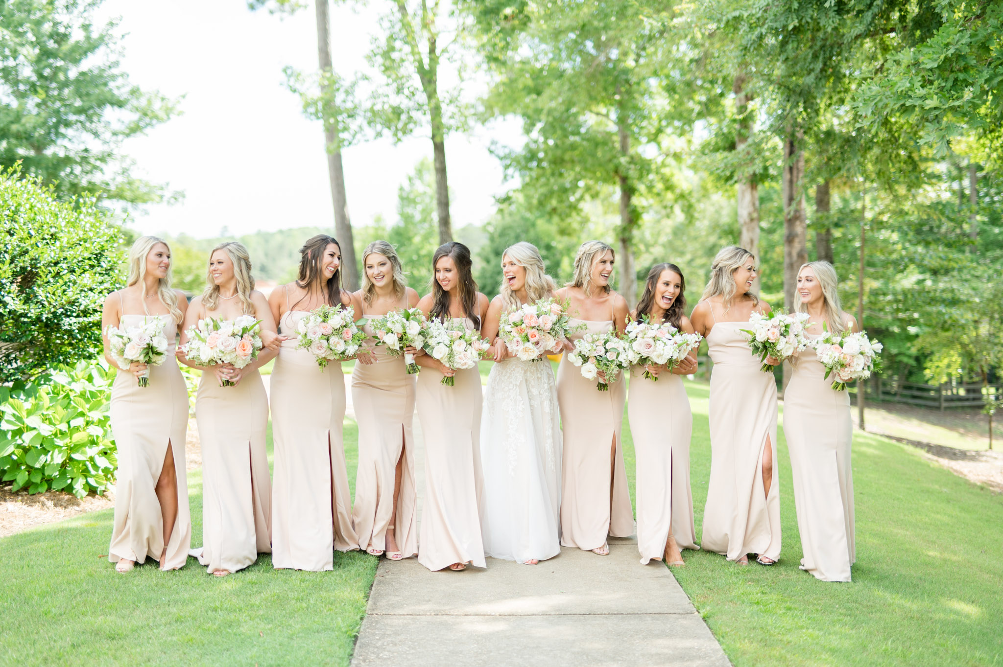Bride walks with her bridesmaids as they laugh.