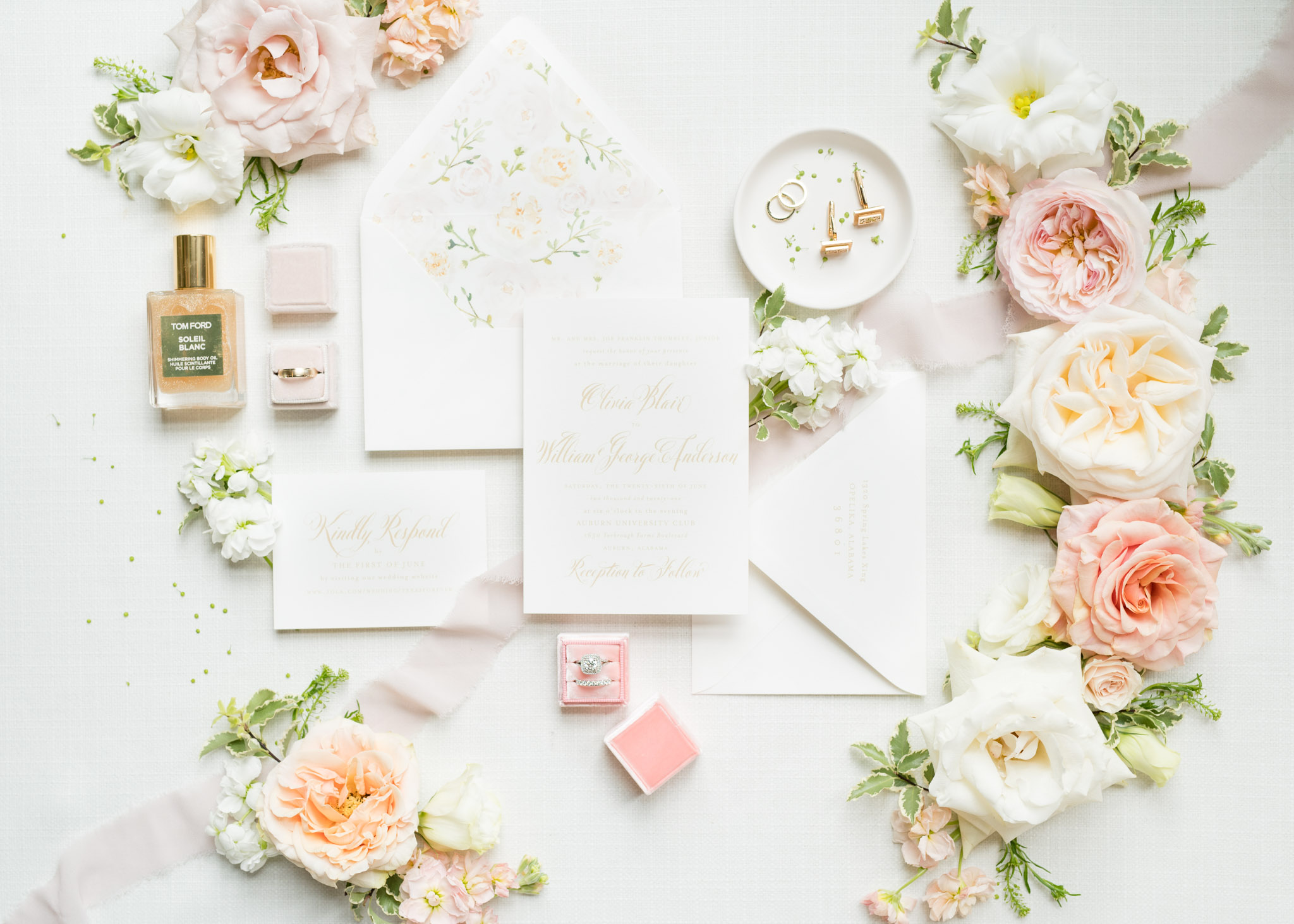 Wedding invitation suite sits with bridal details.