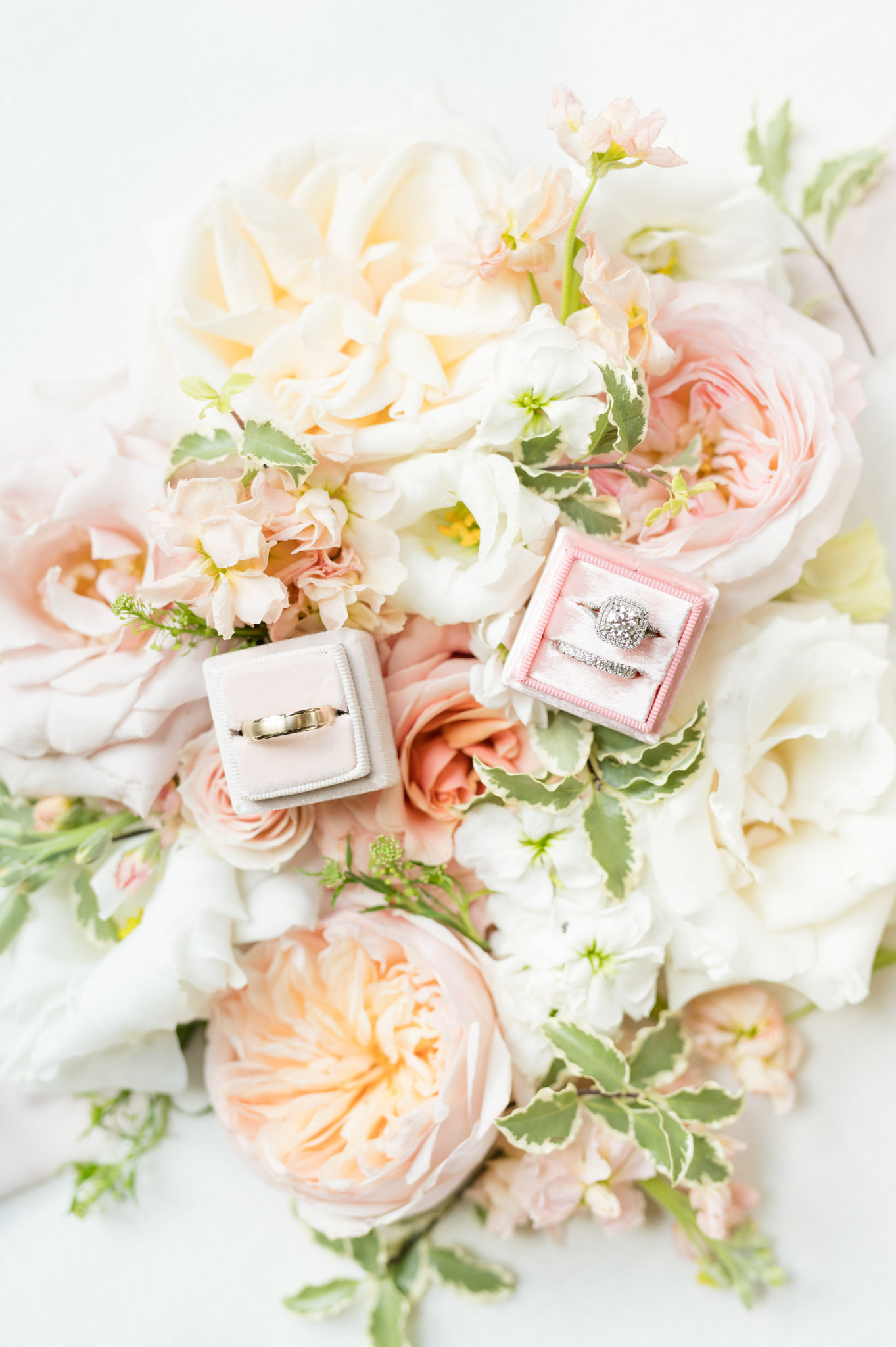 Wedding rings sit on flowers.