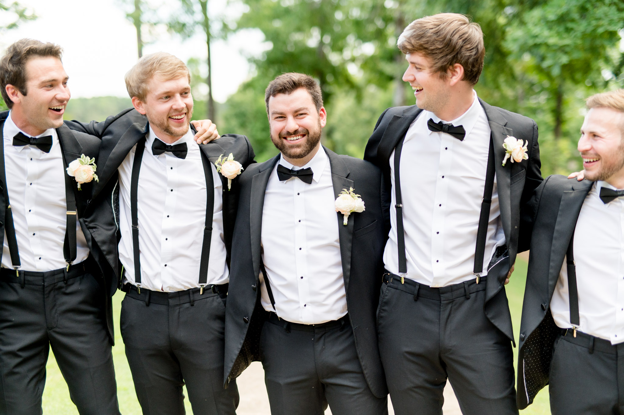 Groom laughs with groomsmen.