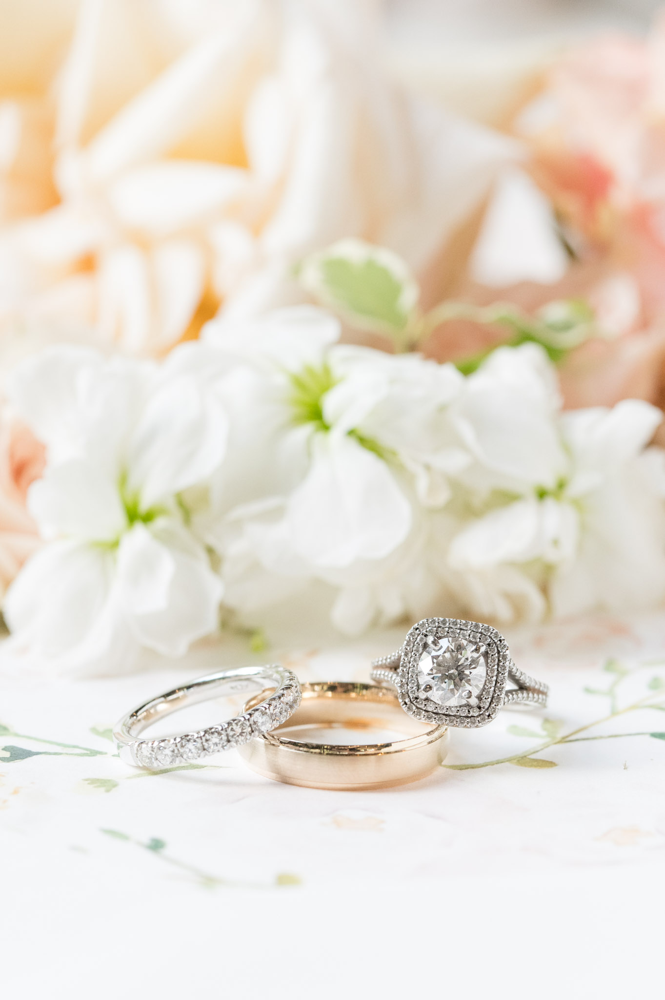 Wedding rings sit next to flowers.