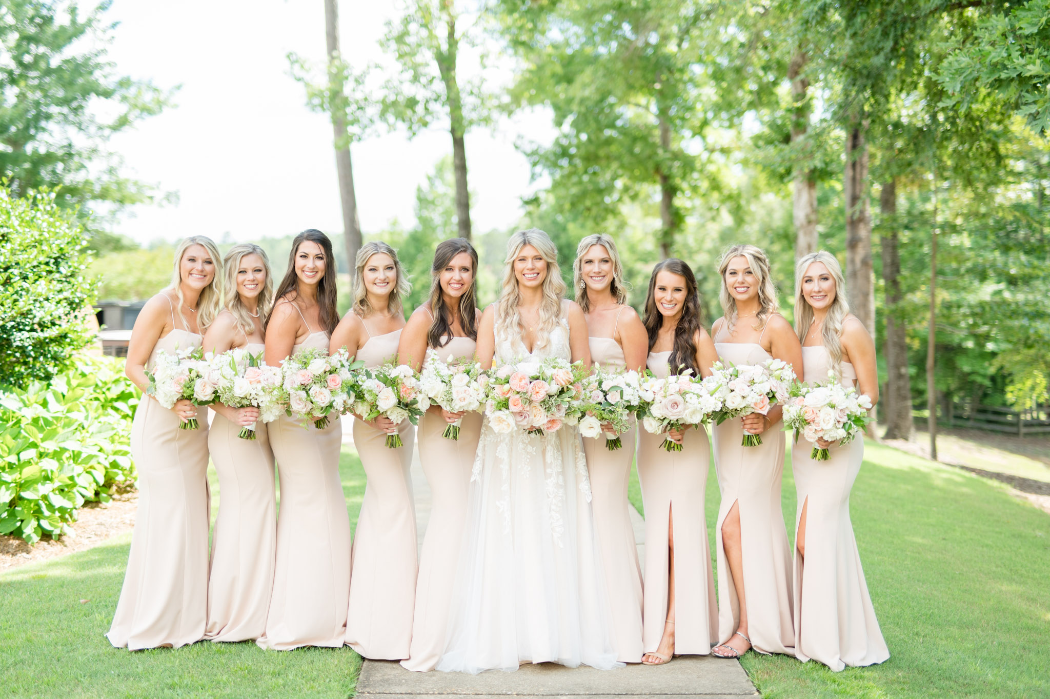 Bride and bridesmaids smile at camera together.