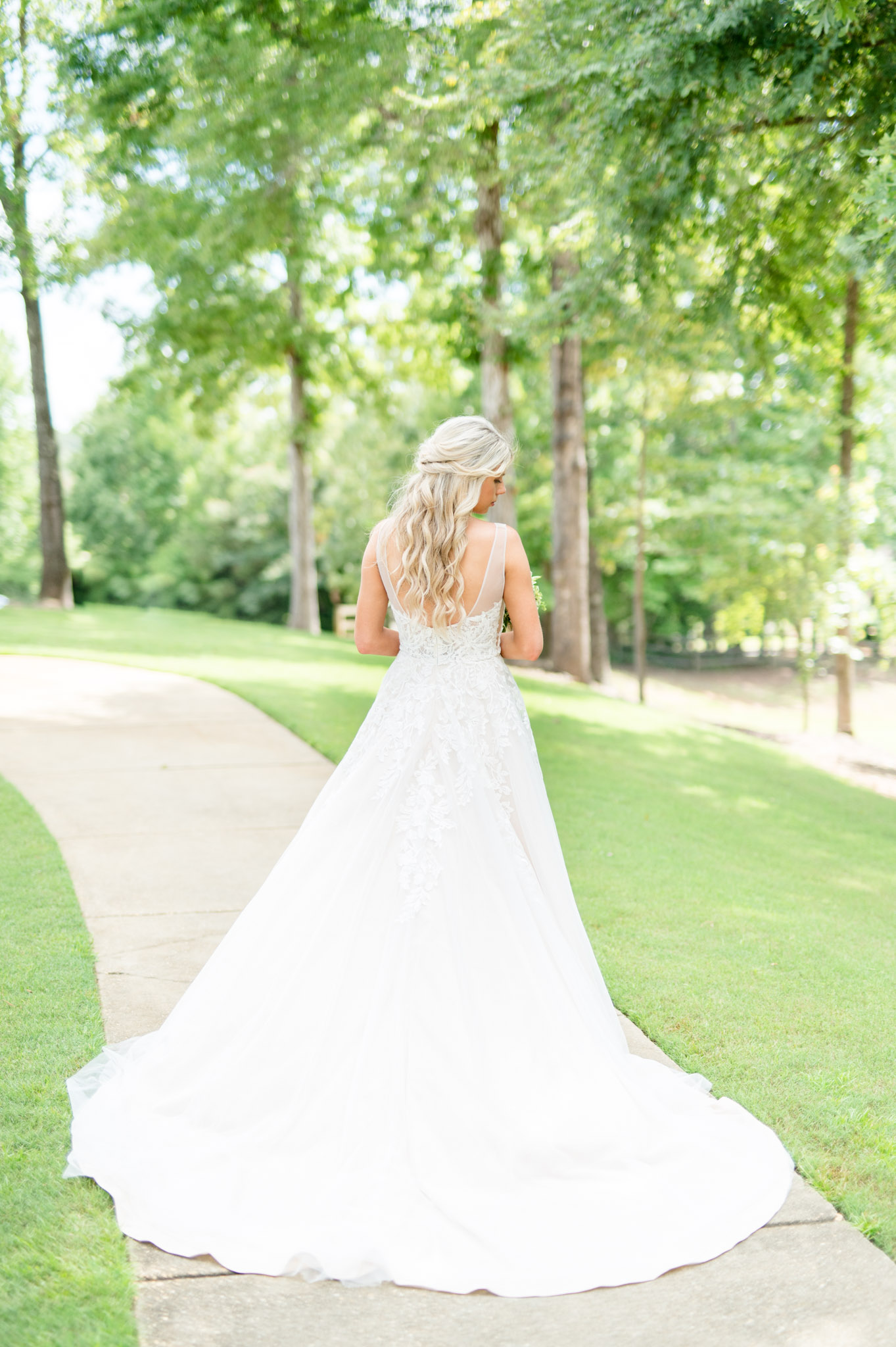 Bride looks over shoulder while showing off back of dress.