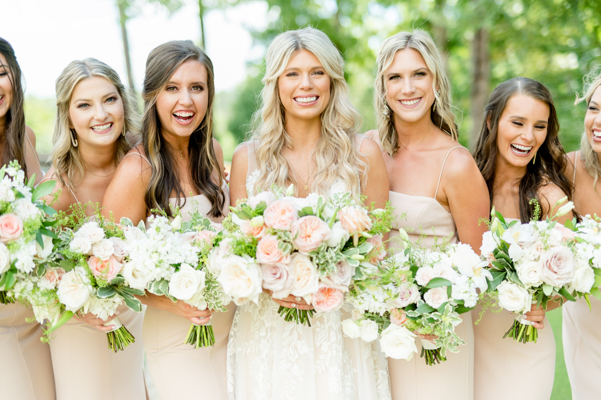 Bride and her maids smile at the camera.