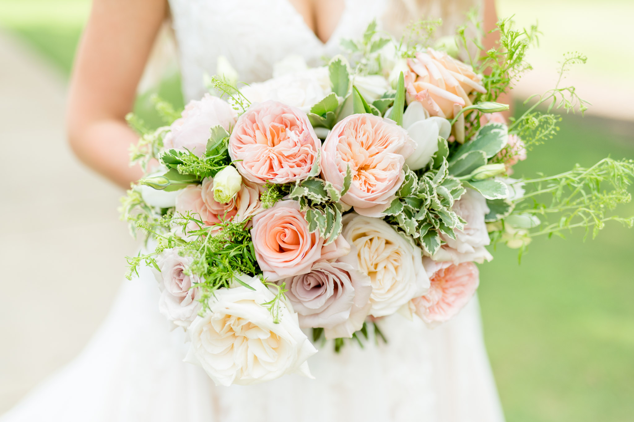 Blush and white flowers held by bride.