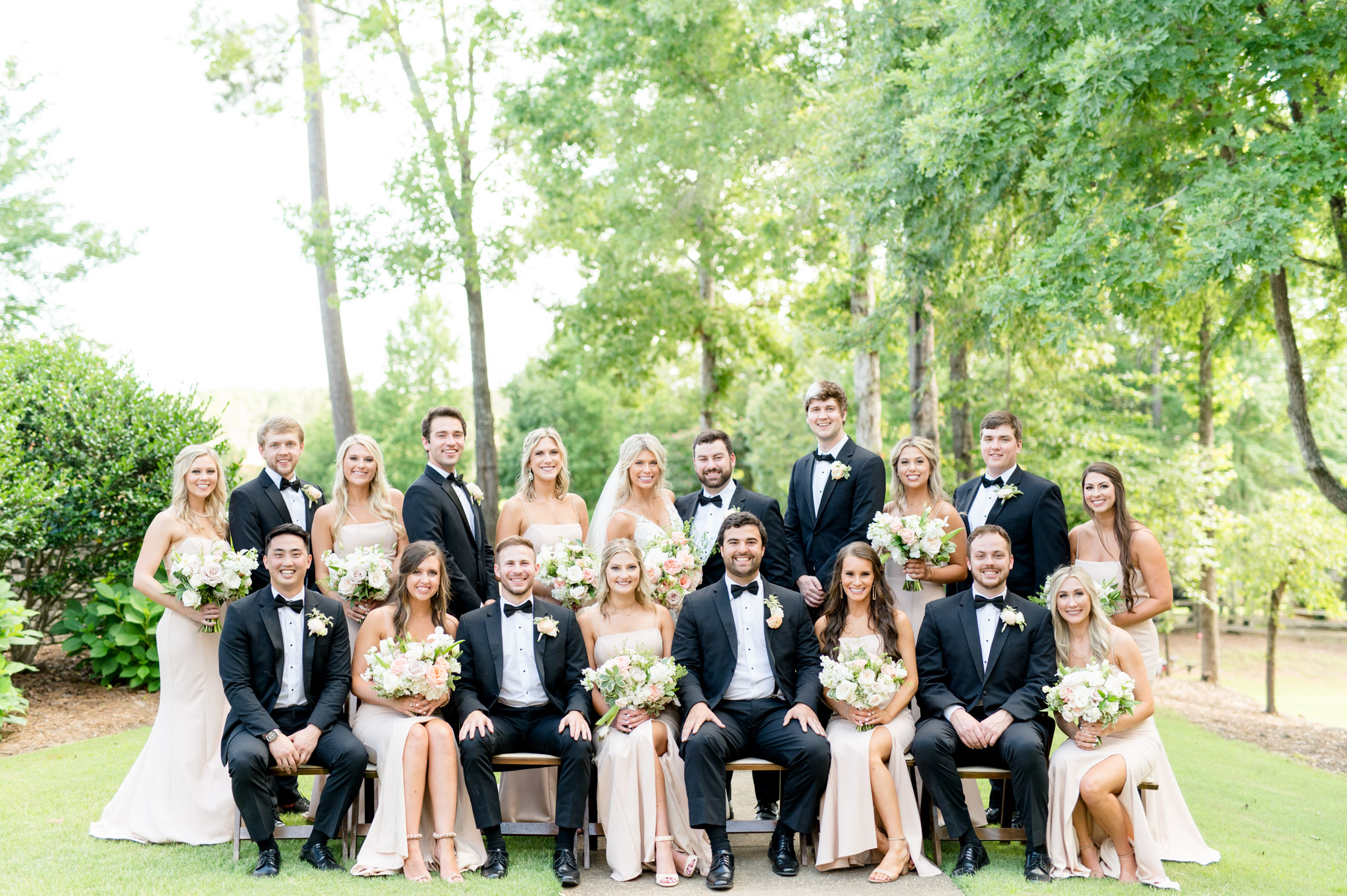 Wedding couple and wedding party smile at camera.