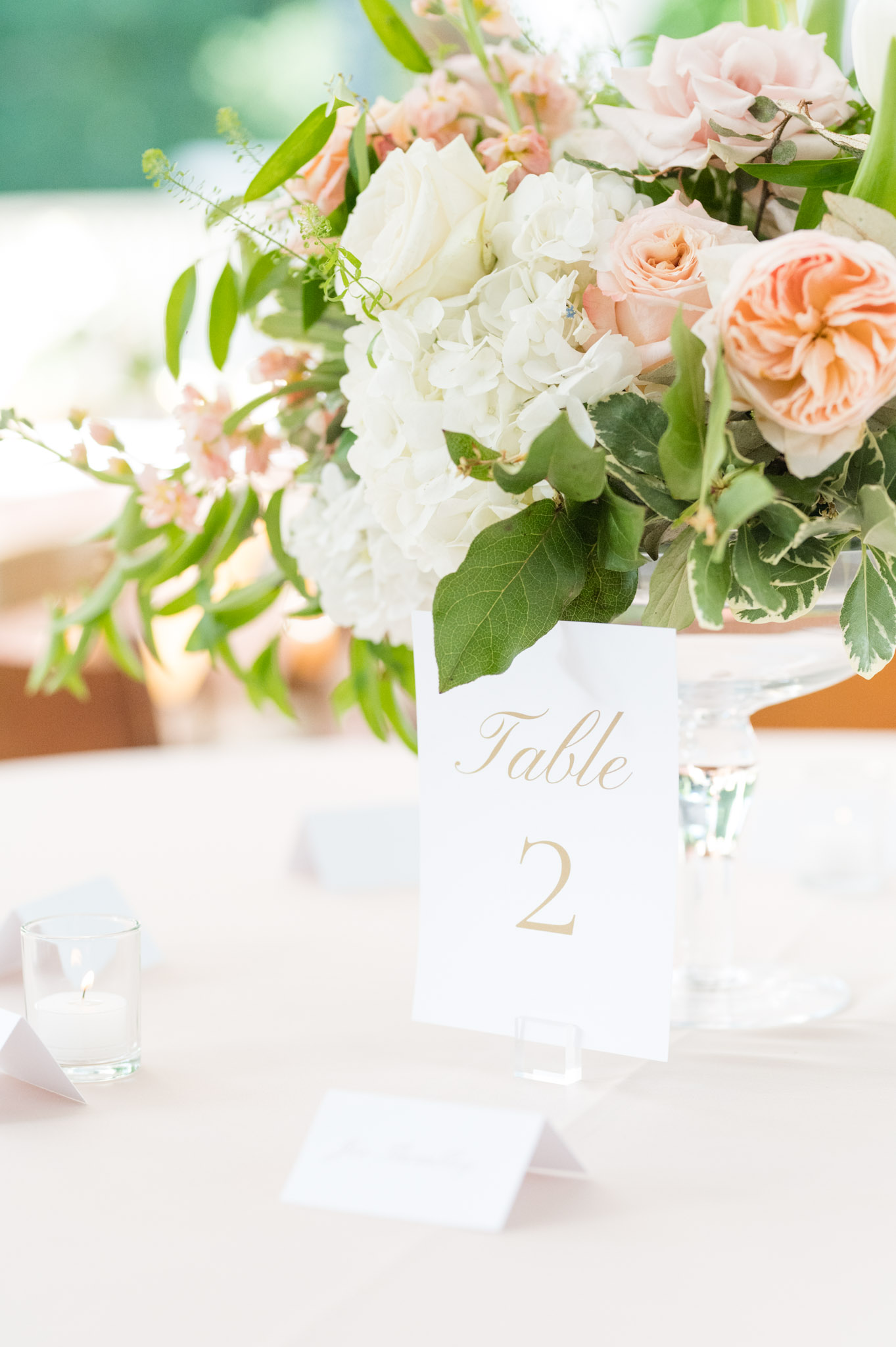 Closeup of table numbers and floral arrangements.