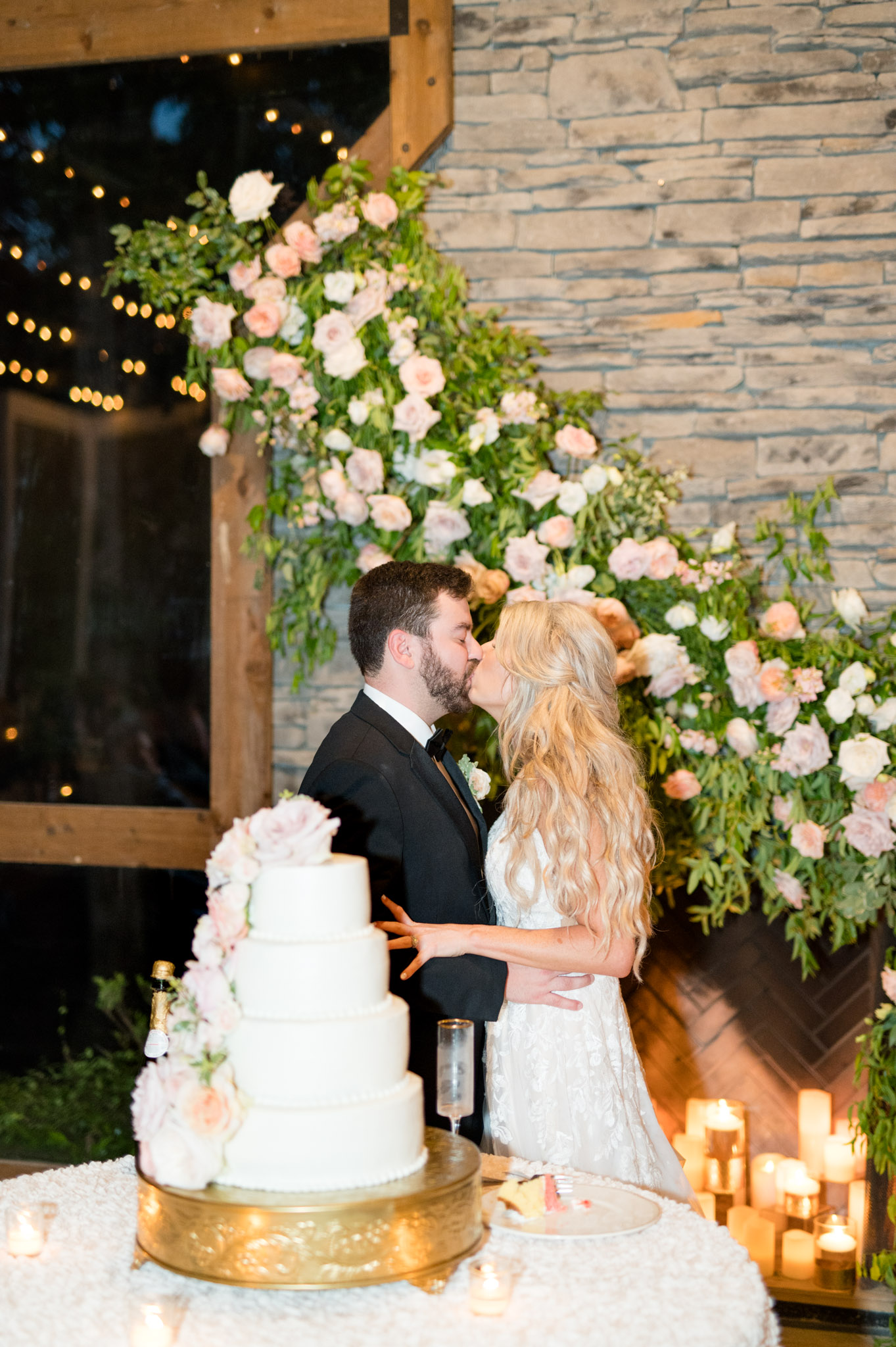 Bride and groom kiss after cutting cake.