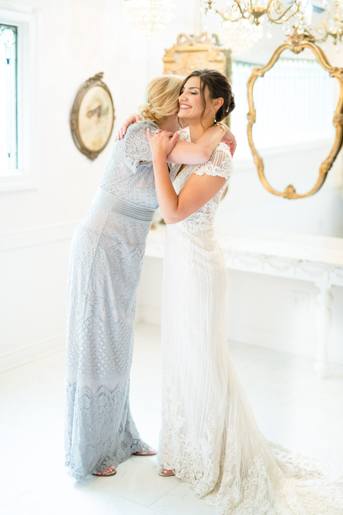 Bride hugs mother while getting ready.