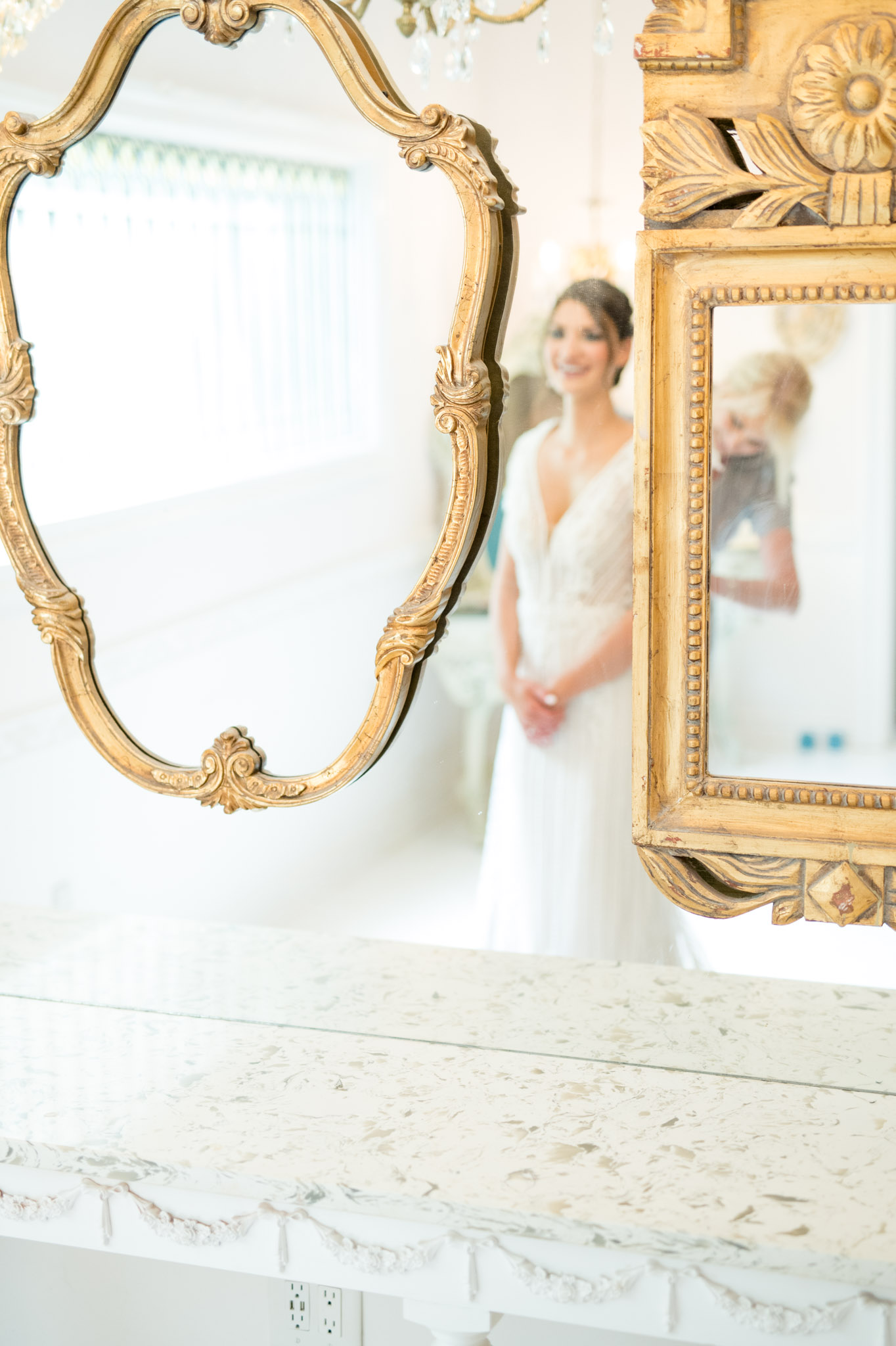 Reflection of bride in mirror while she gets ready.