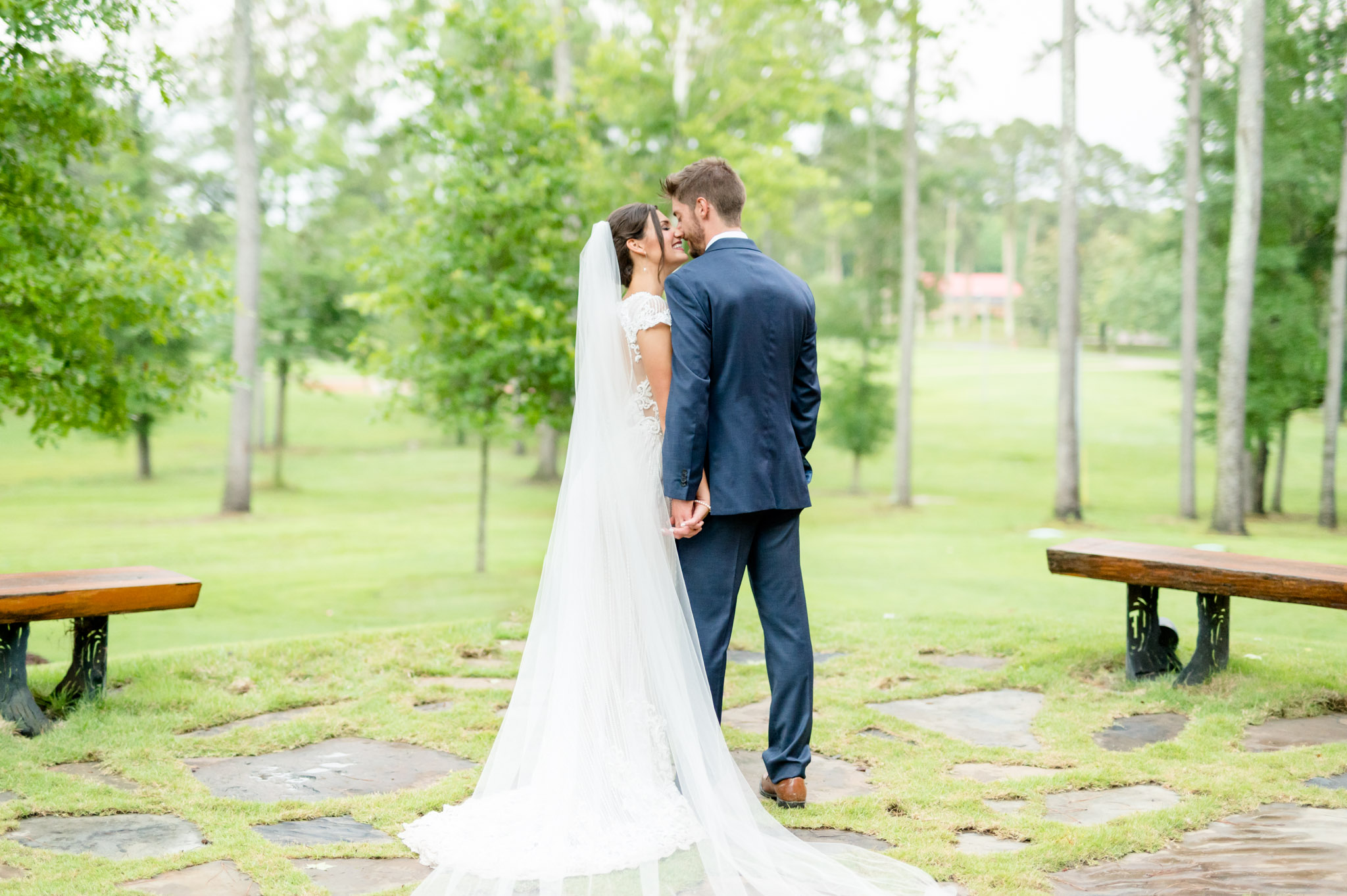 Bride and groom lean in for kiss.