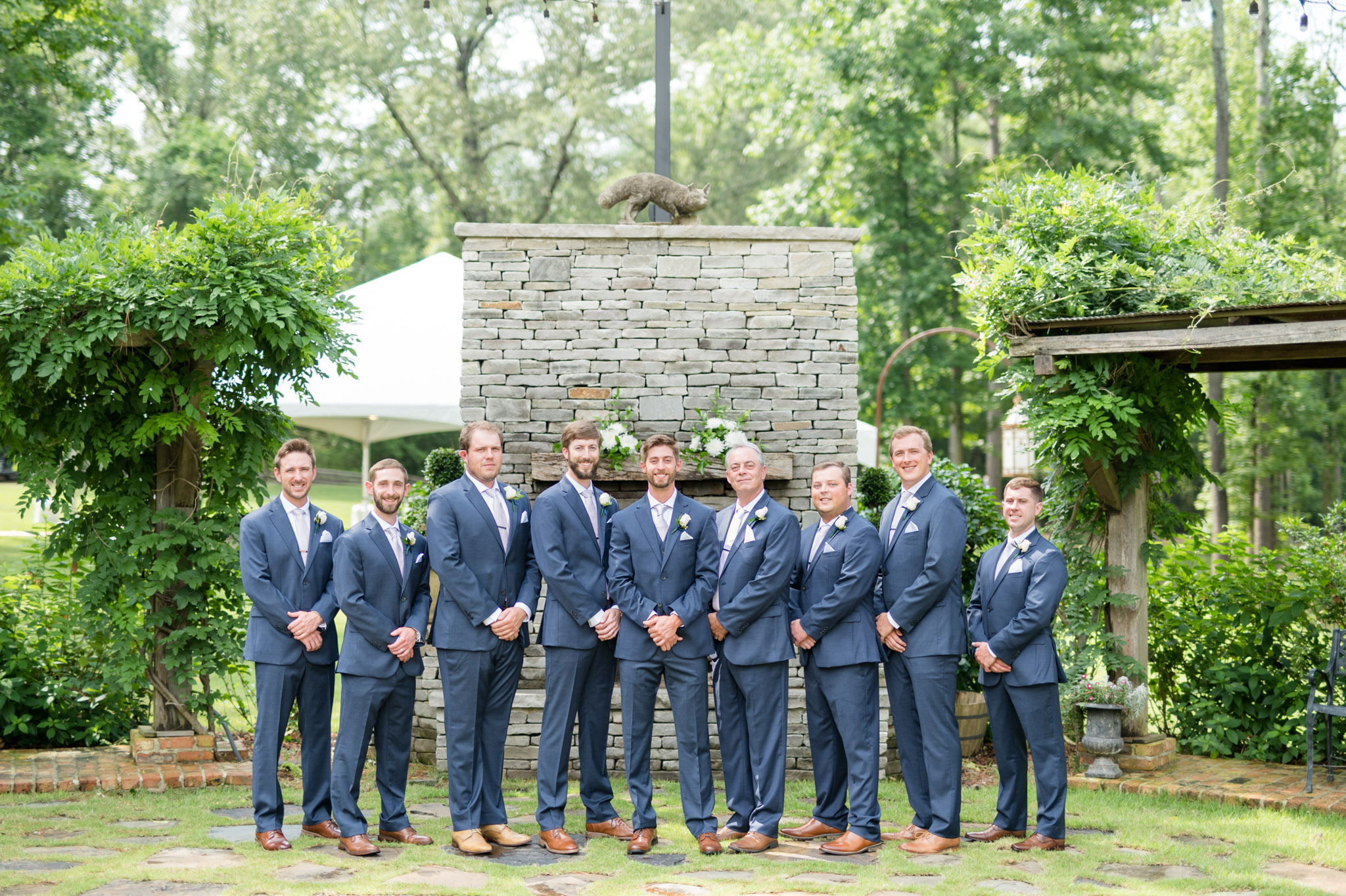 Groom and groomsmen smile at camera.