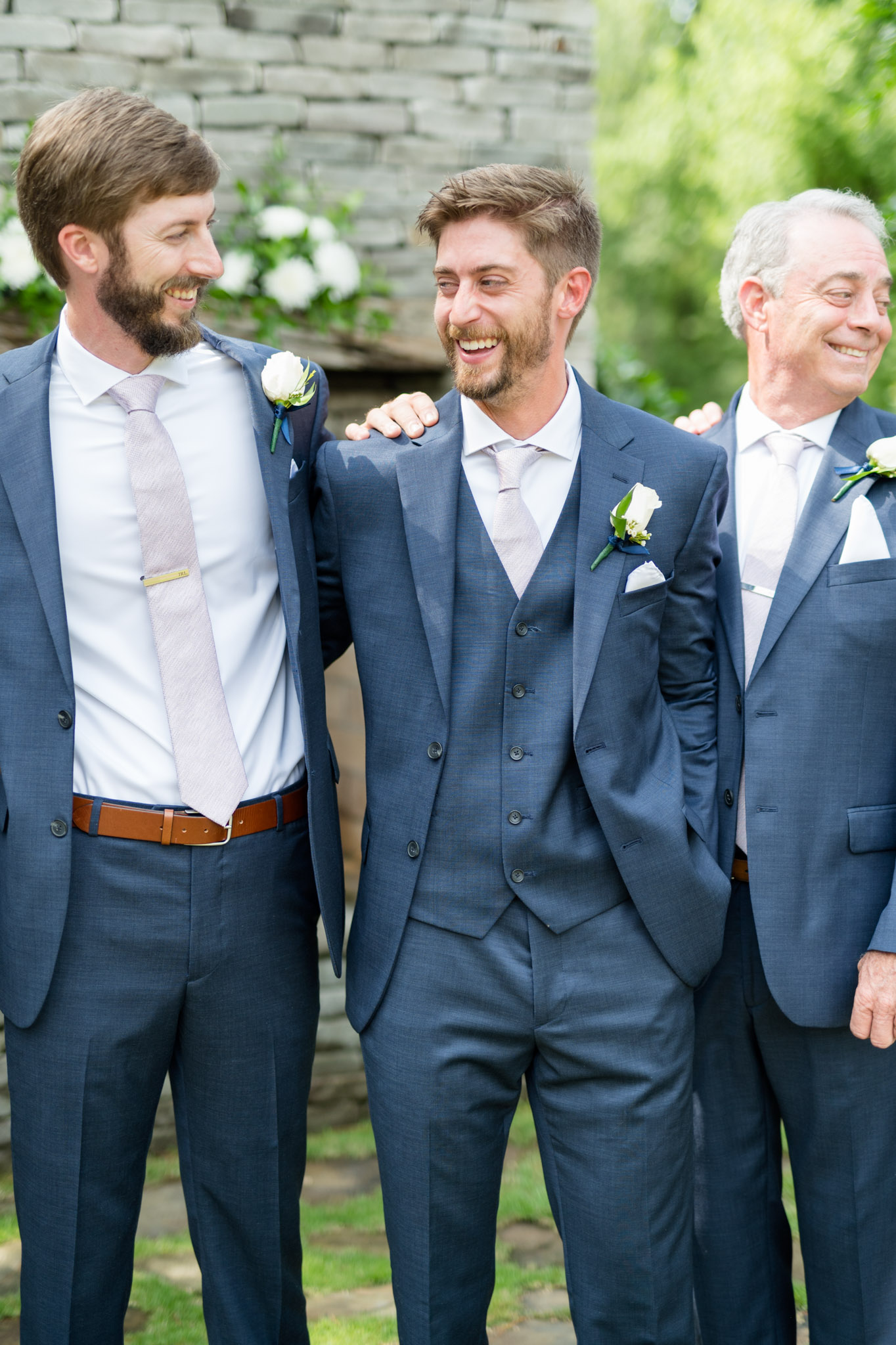Groom laughs with groomsmen.