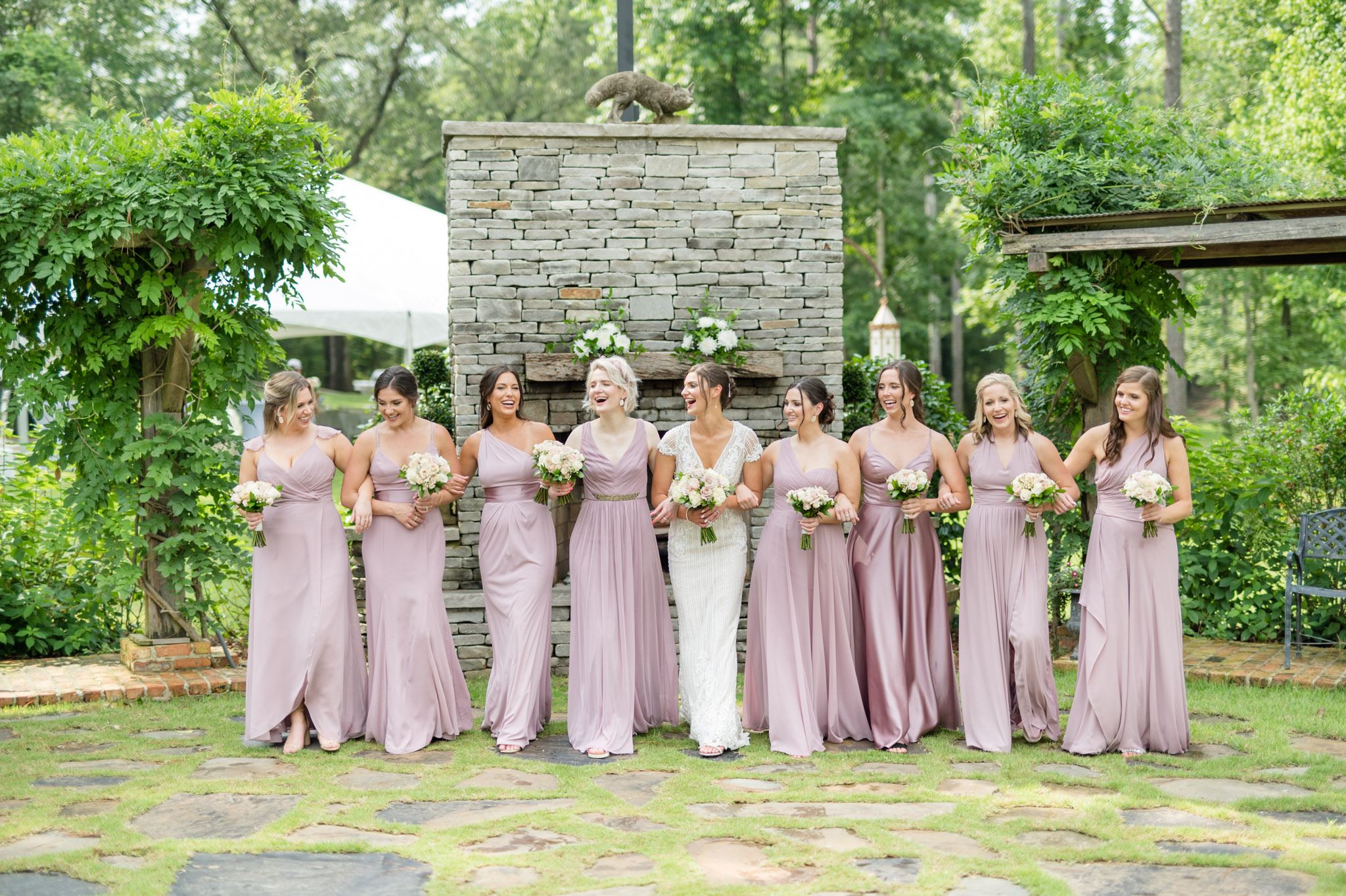 Bride walks with bridesmaids and laugh.