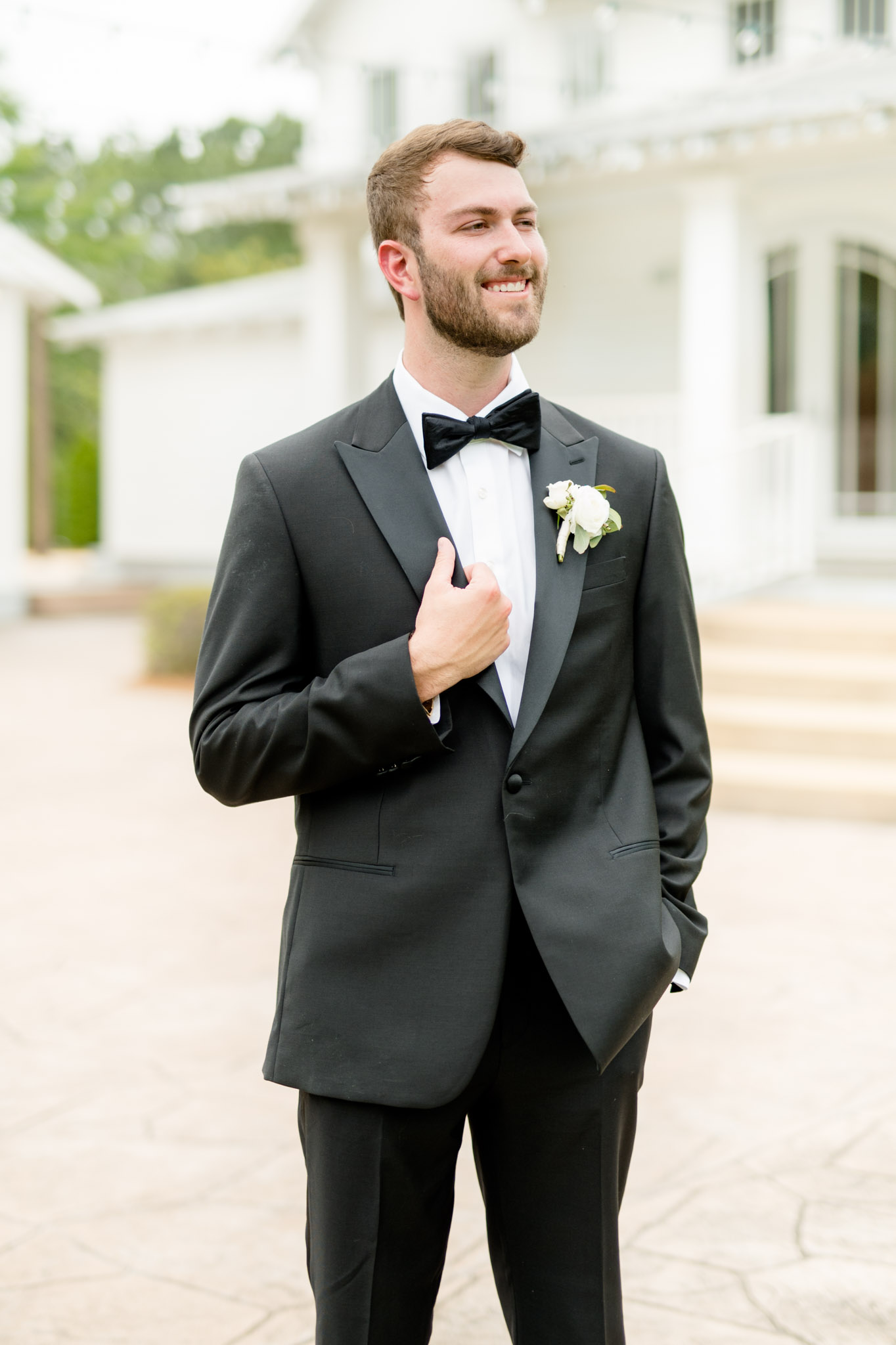 Groom looks over shoulder and smiles.