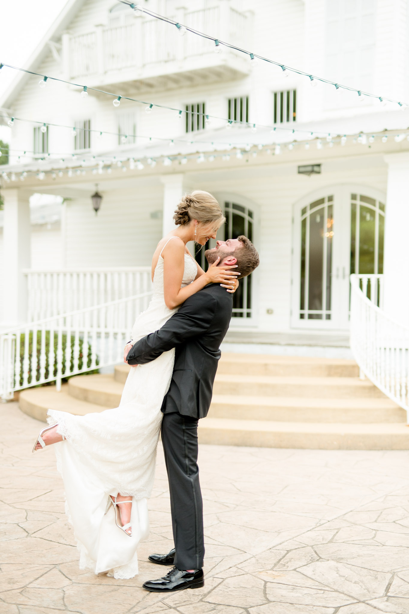 Groom lifts bride for kiss.