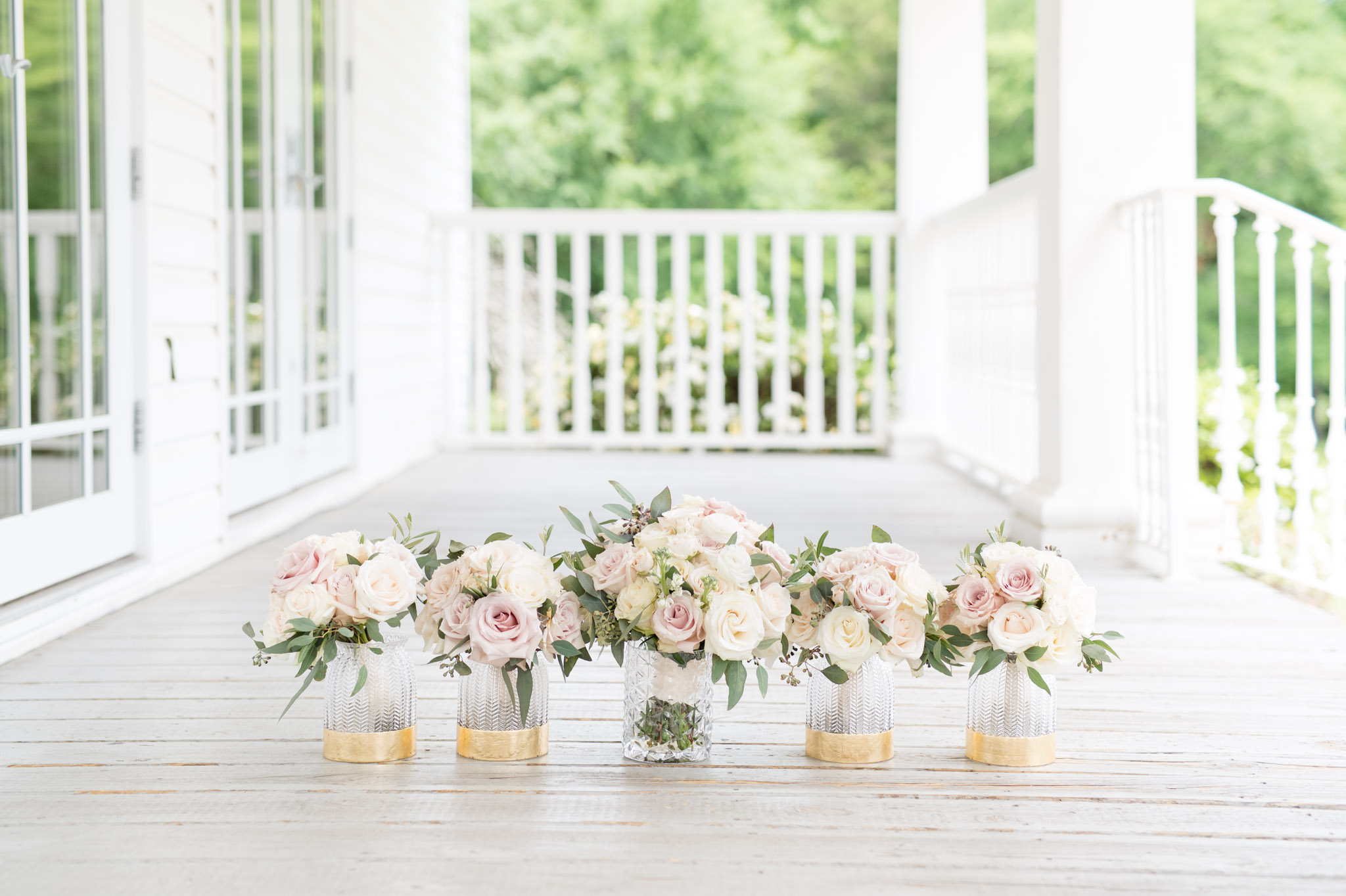 Bridal party bouquets sit in vases.