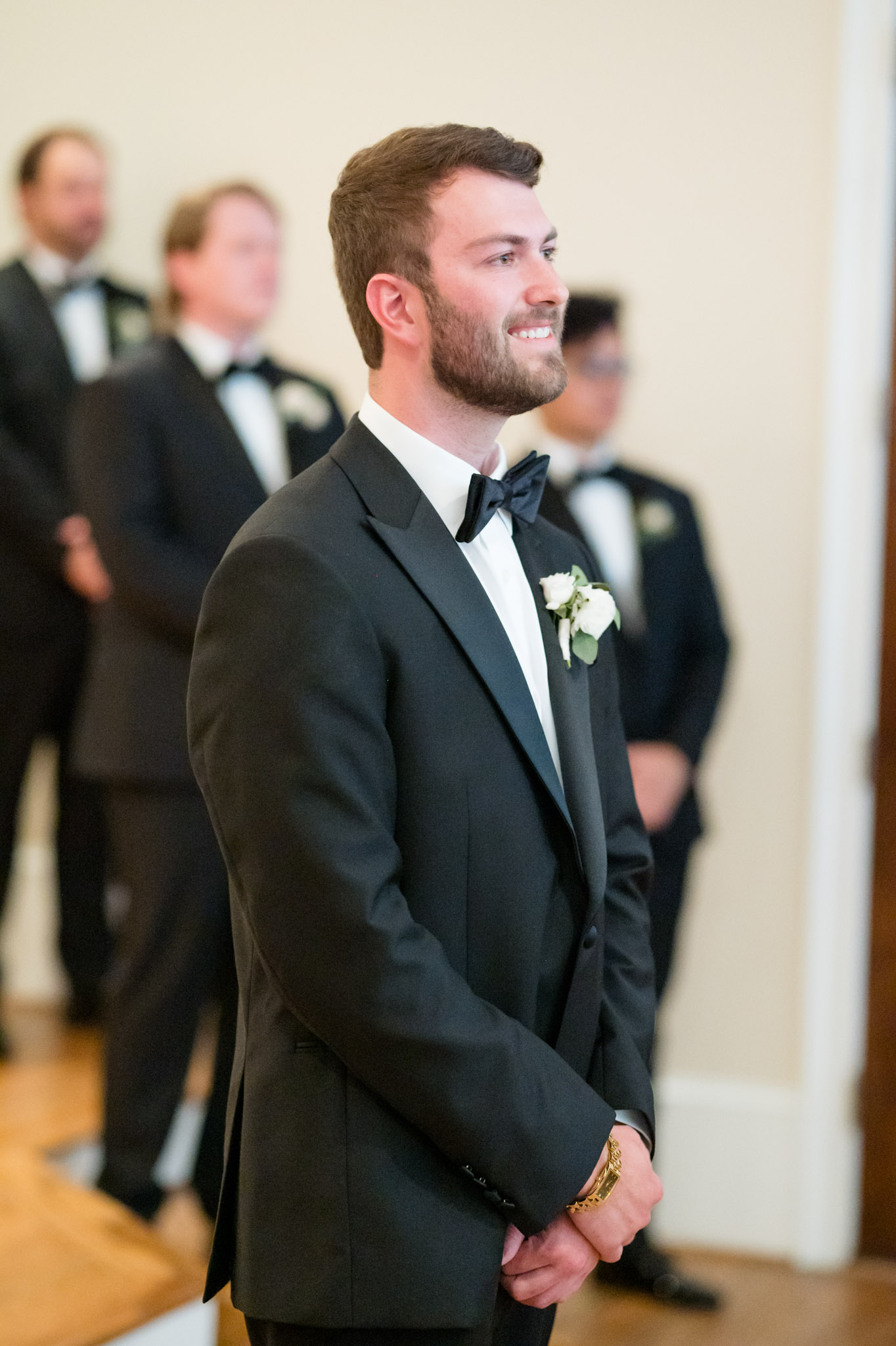 Groom smiles at bride as she comes down aisle.