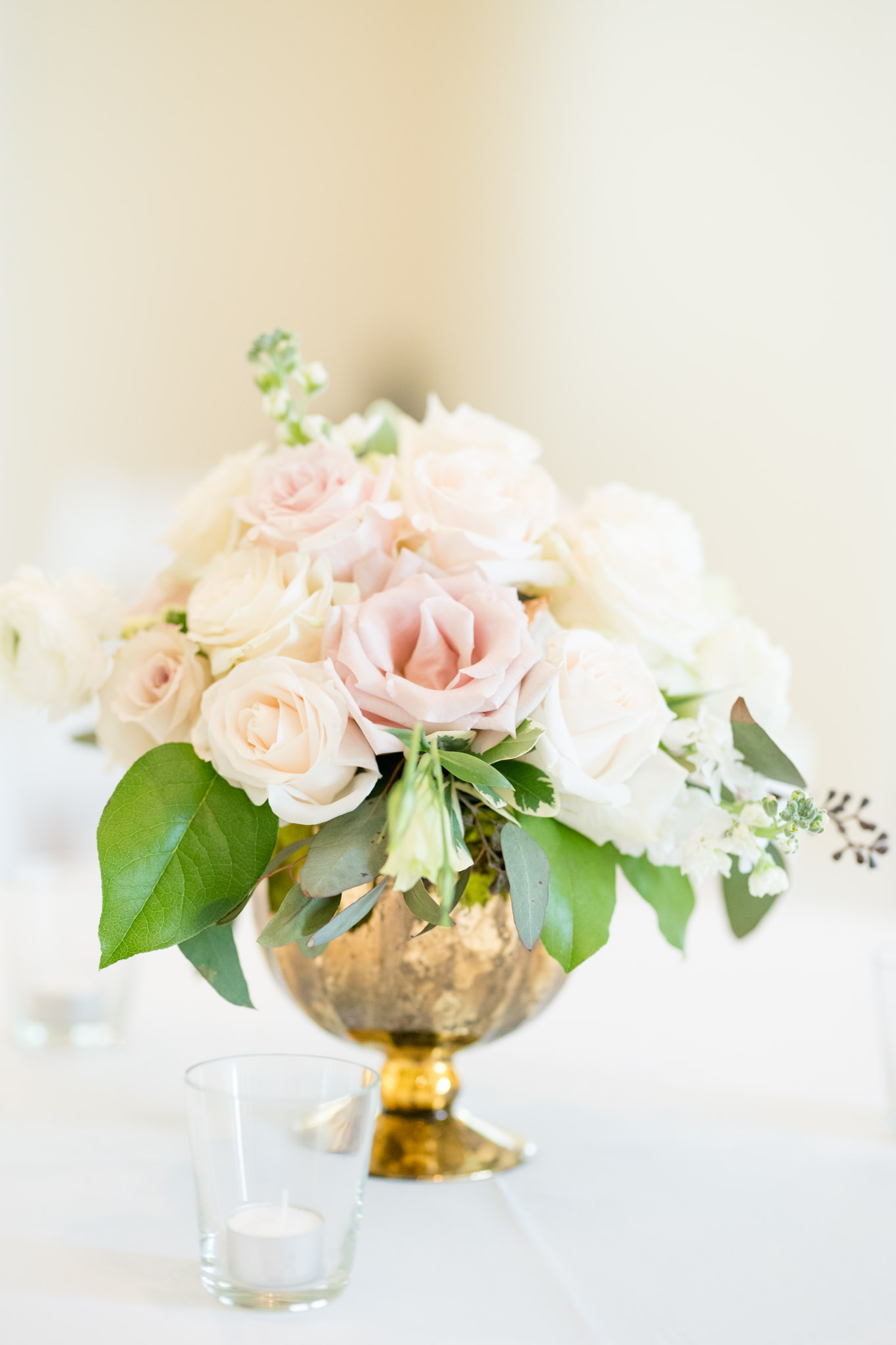 Pink and cream flowers sit on reception table.