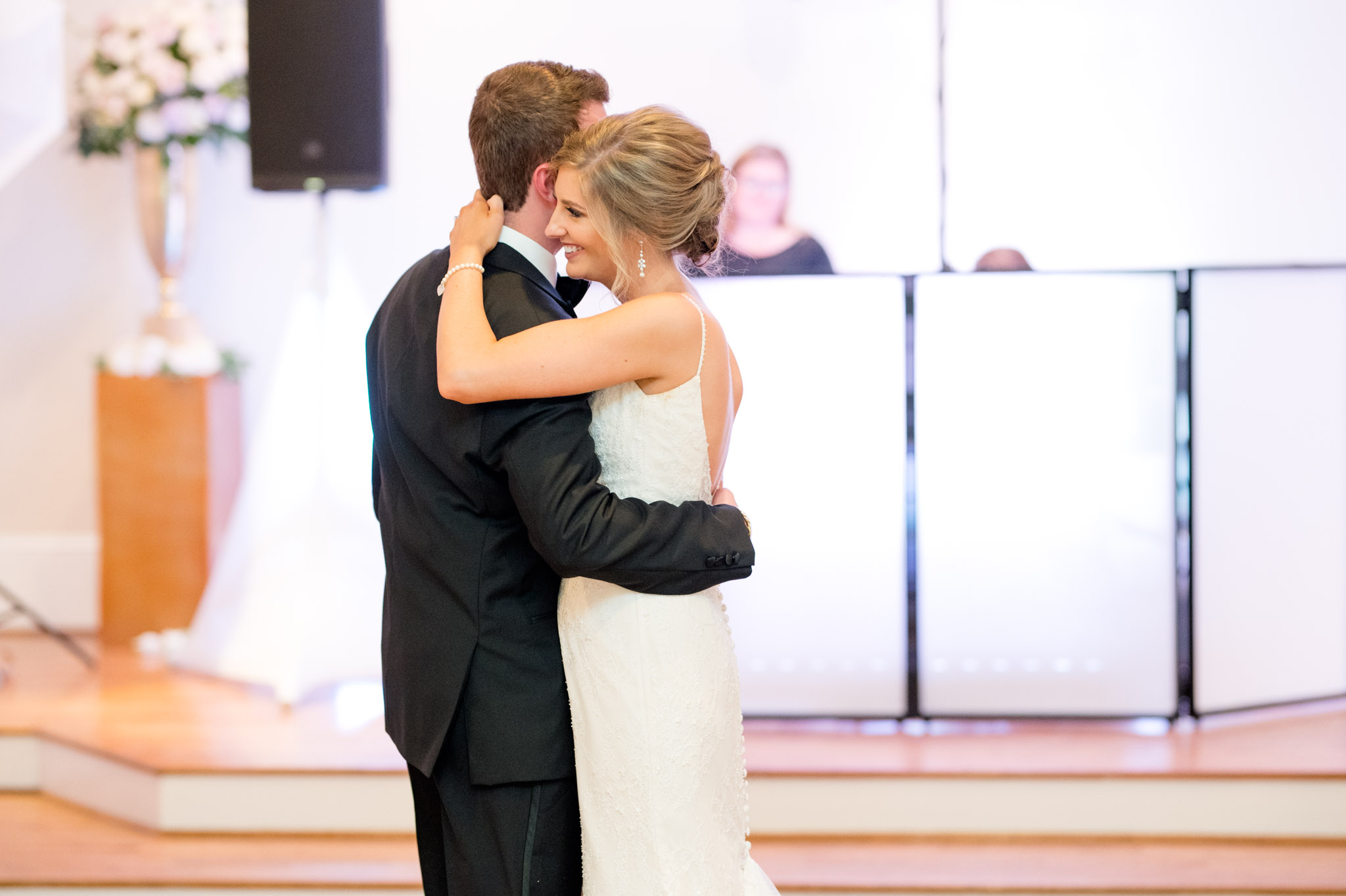 Bride smiles while dancing with groom.