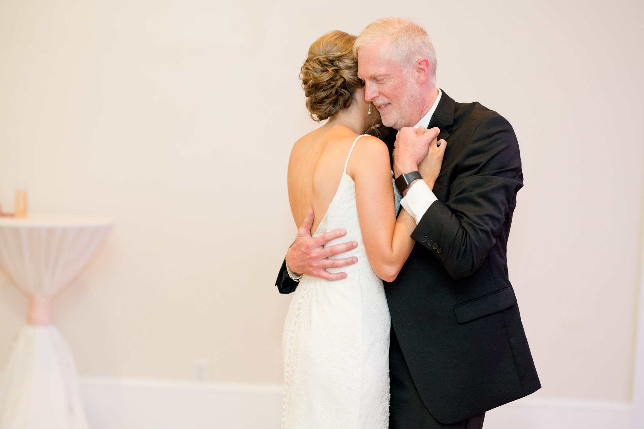 Bride's father holds her close during dance.