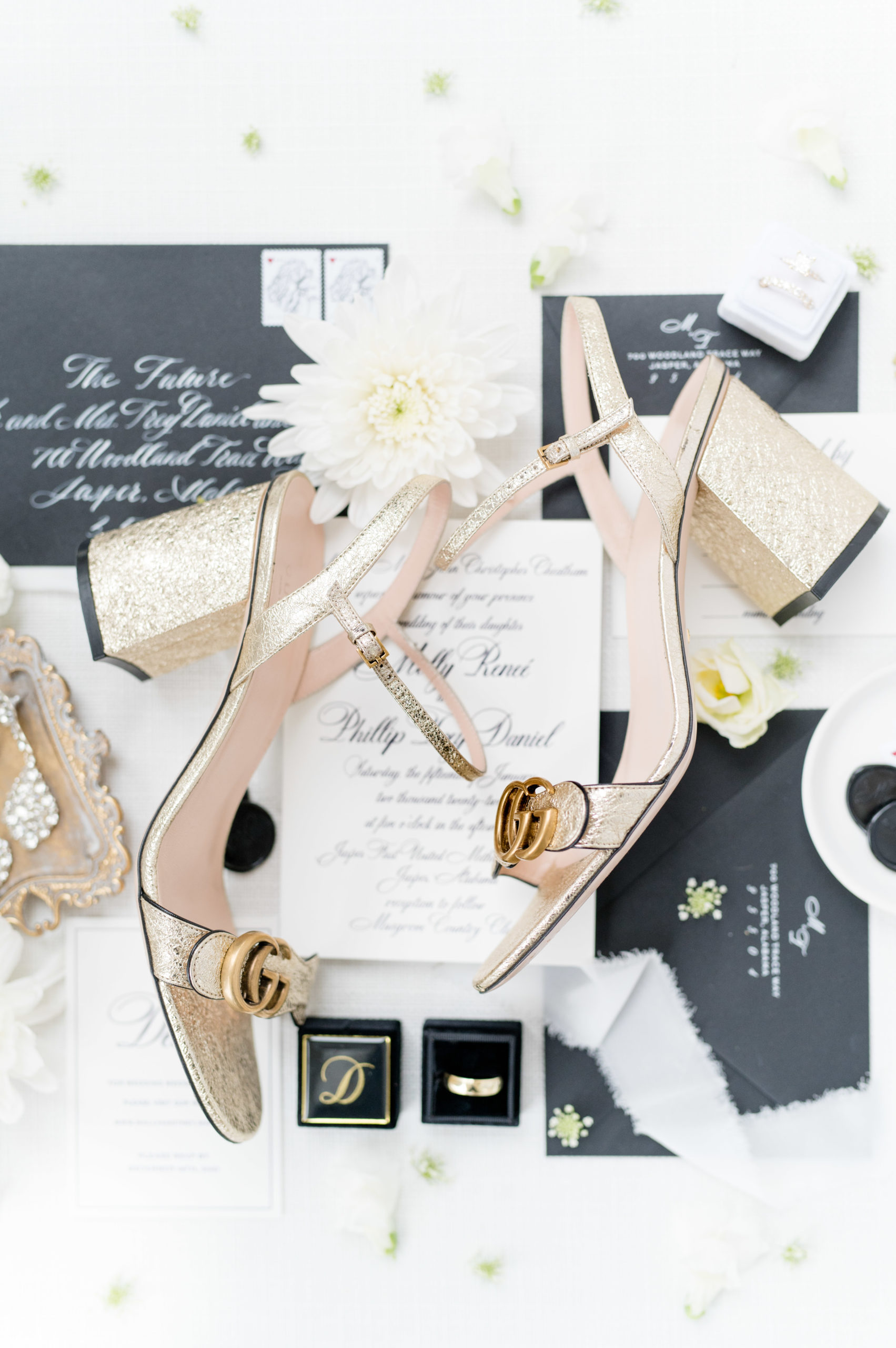 Bride's shoes sit with wedding invitation.