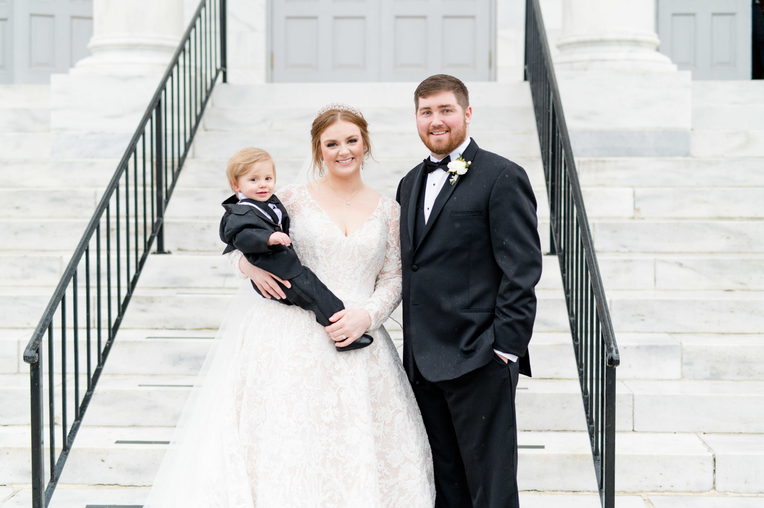 Bride and groom hold son.