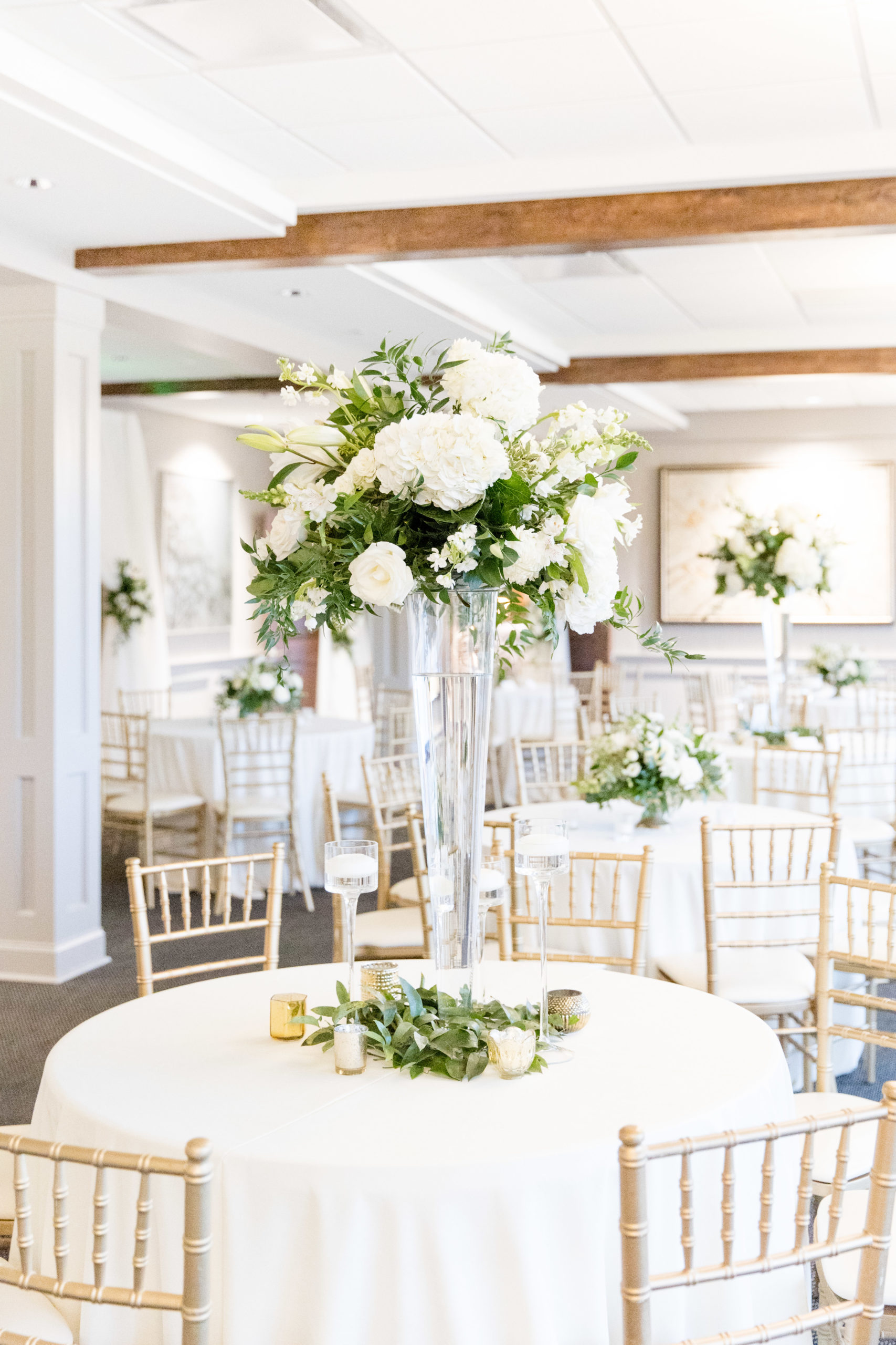 White flowers sit on wedding reception tables.
