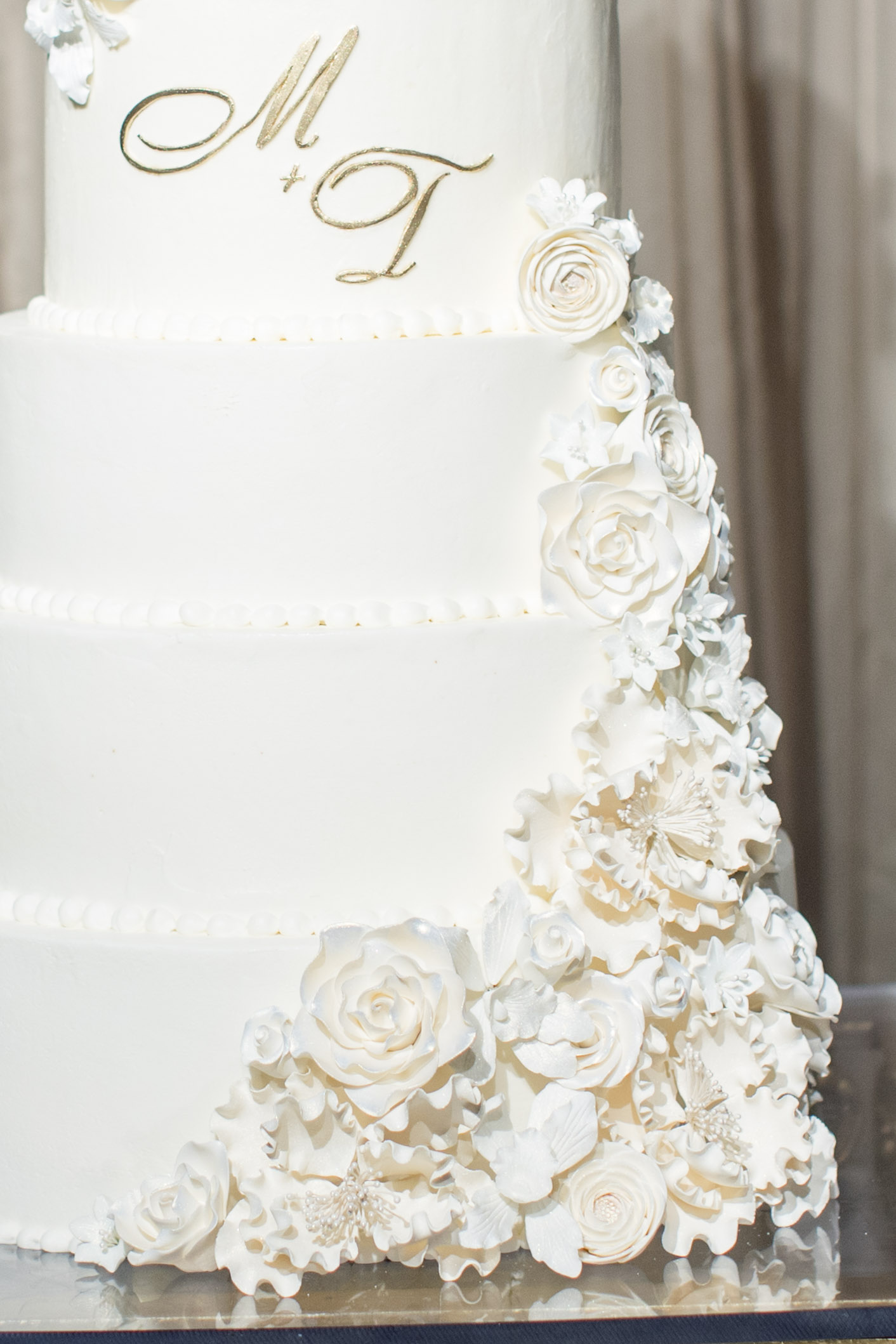 Sugar flowers on large white wedding cake.