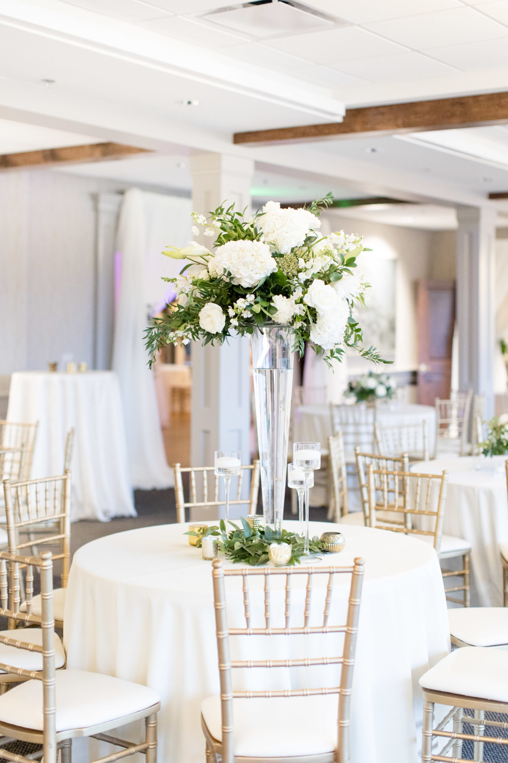 Floral centerpieces sit on reception tables.