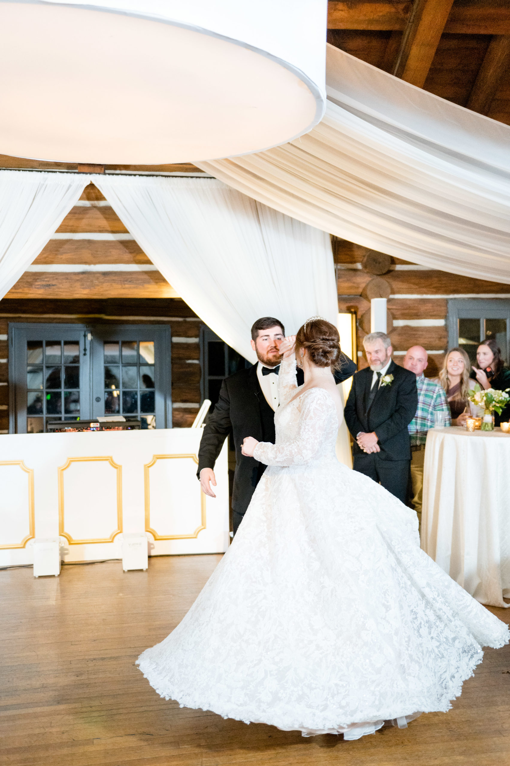 Groom twirls bride during first dance.