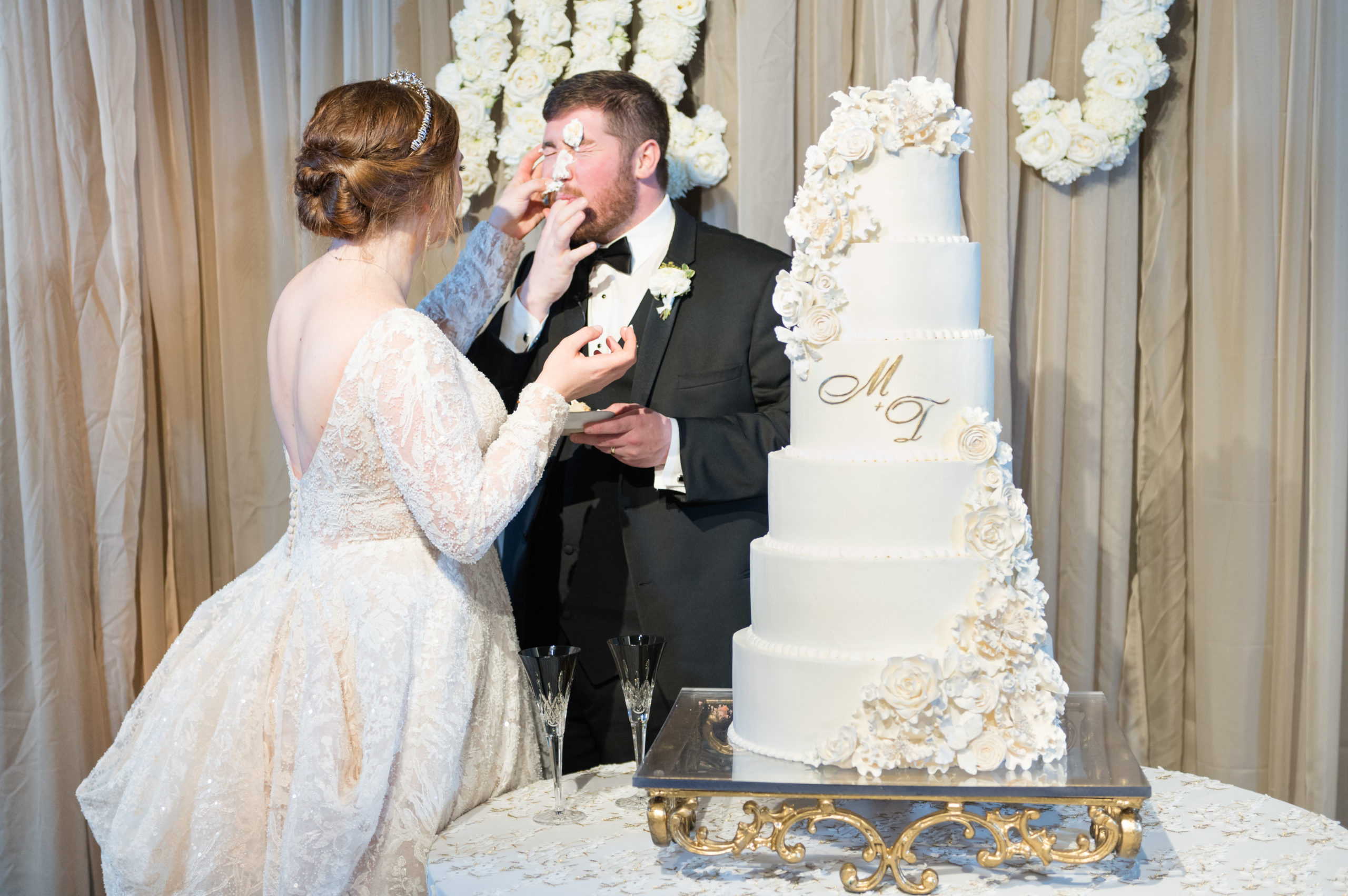 Bride smears cake on groom's face.