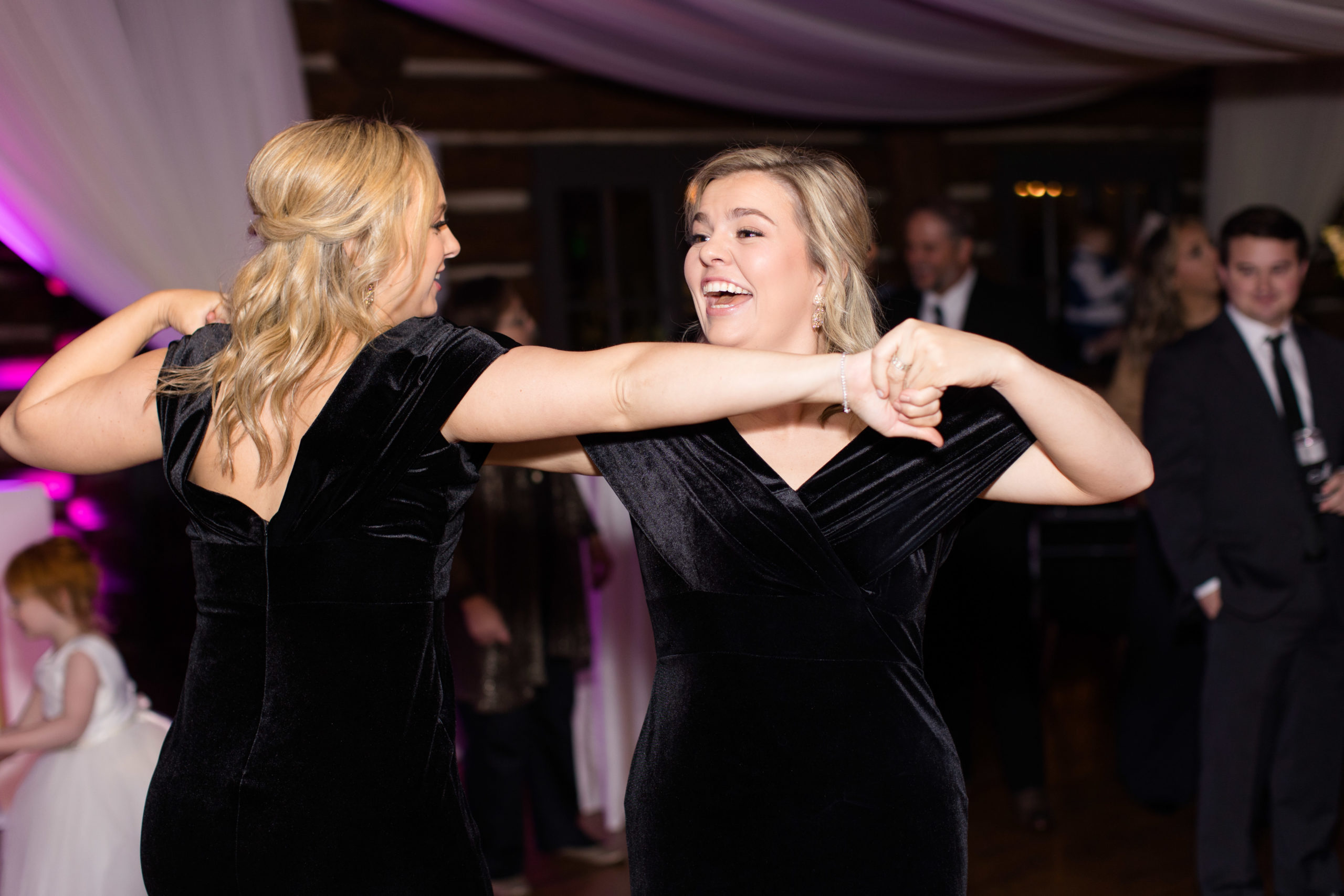Bridesmaids dance together at reception.