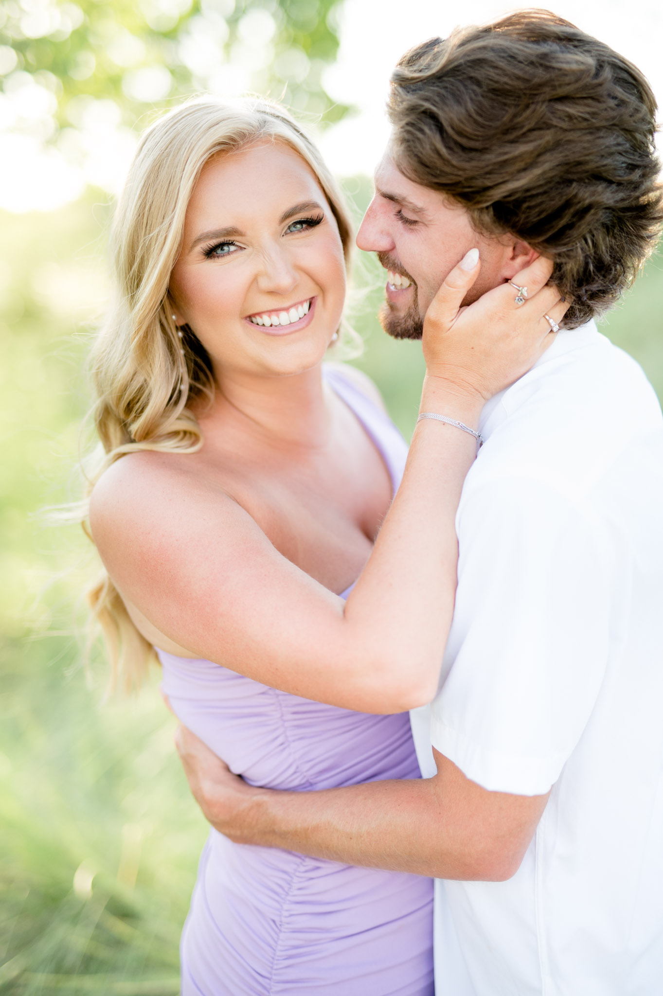 Bride-to-be smiles as fiance smiles at her.