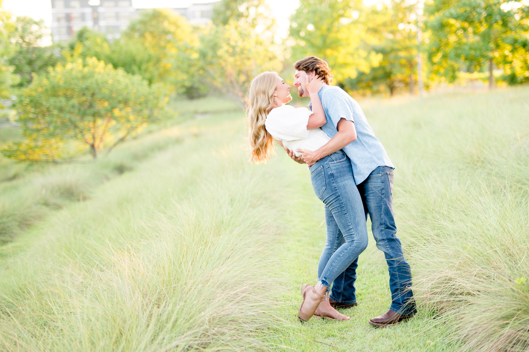 Man dips woman back at sunset.