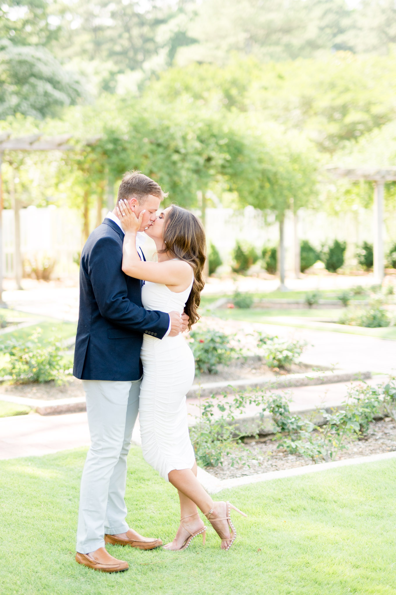 Couple kisses at botanical garden.