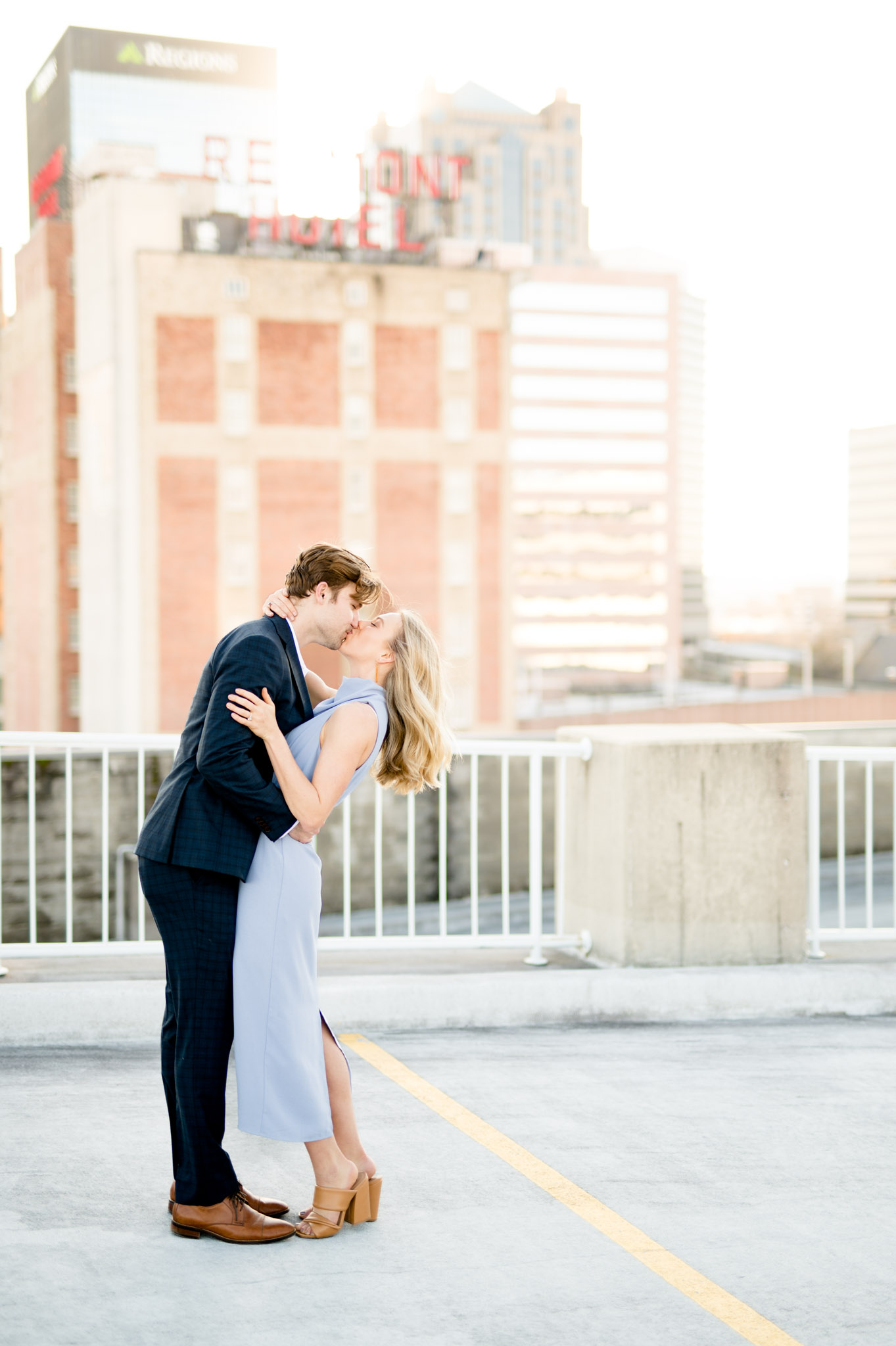 Couple kiss on rooftop of building.