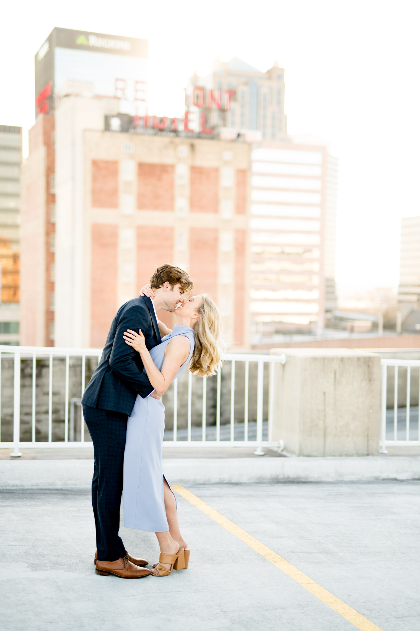 Couple kisses on rooftop in city.