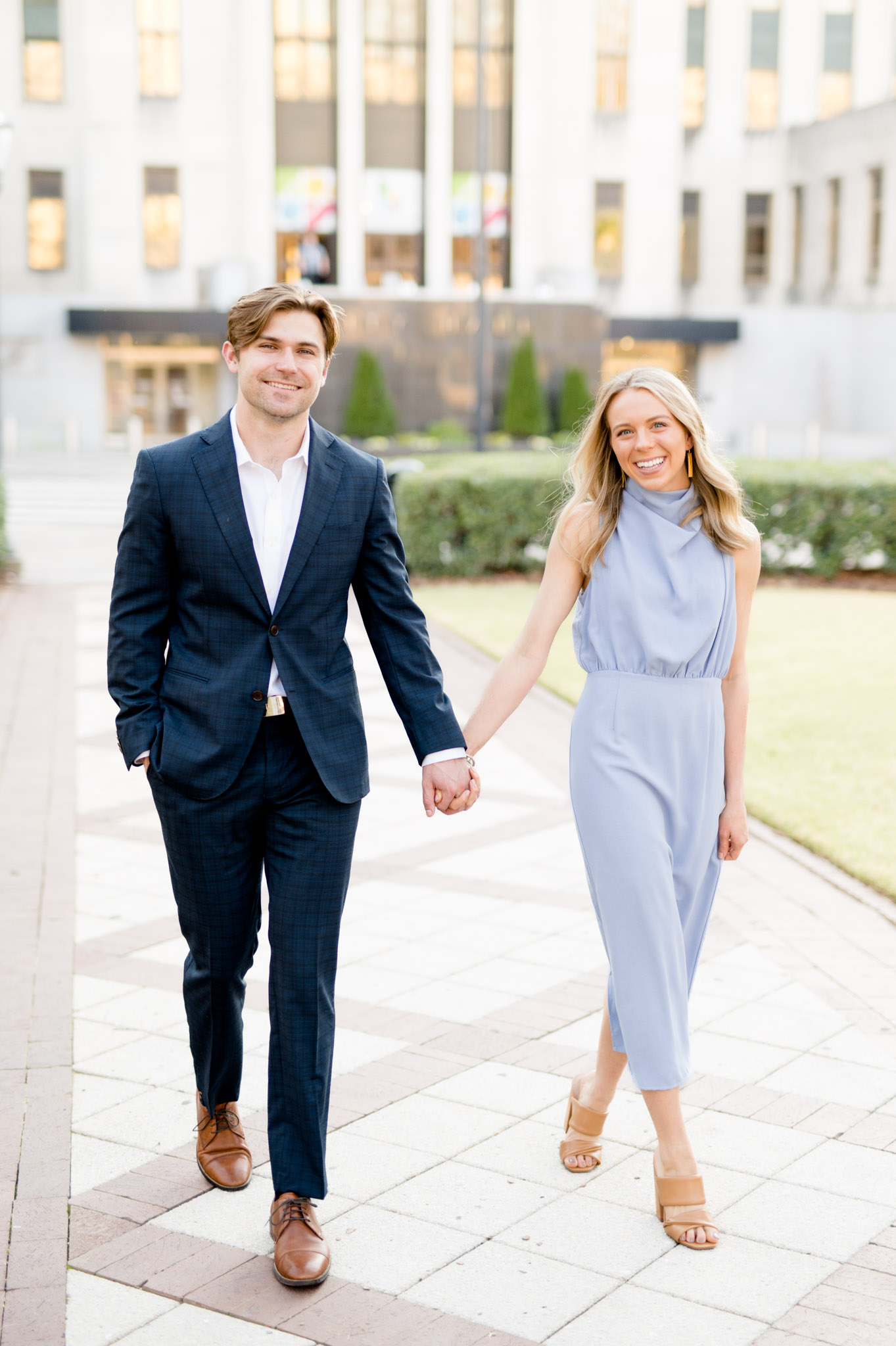 Couple walks and smiles at camera.